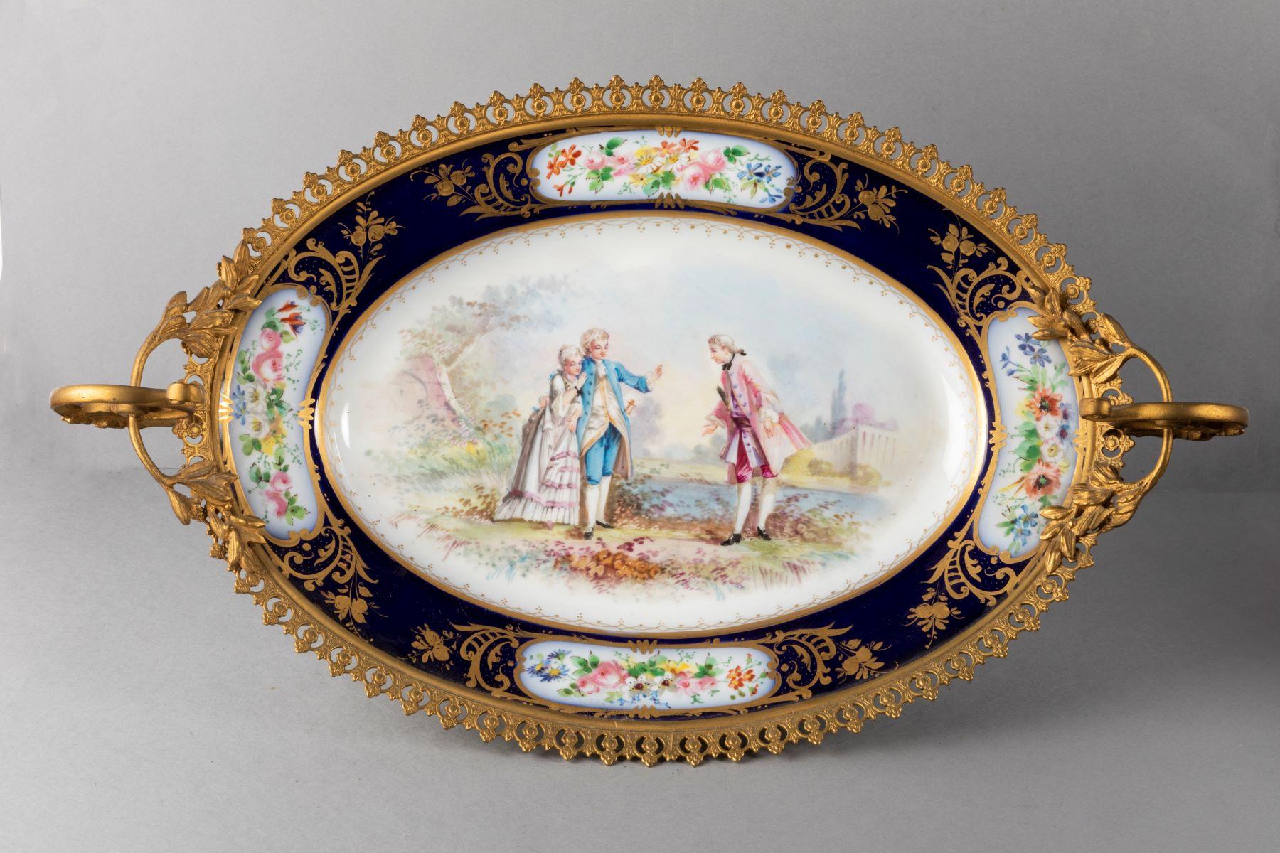 Rare sevres, gilded bronze dish, platter,
representing a Gallant Scene, a gentleman and a couple in the countryside with a castle in the background, and garlands of flowers on the edges
Most probably part of the collection of the Chateau des