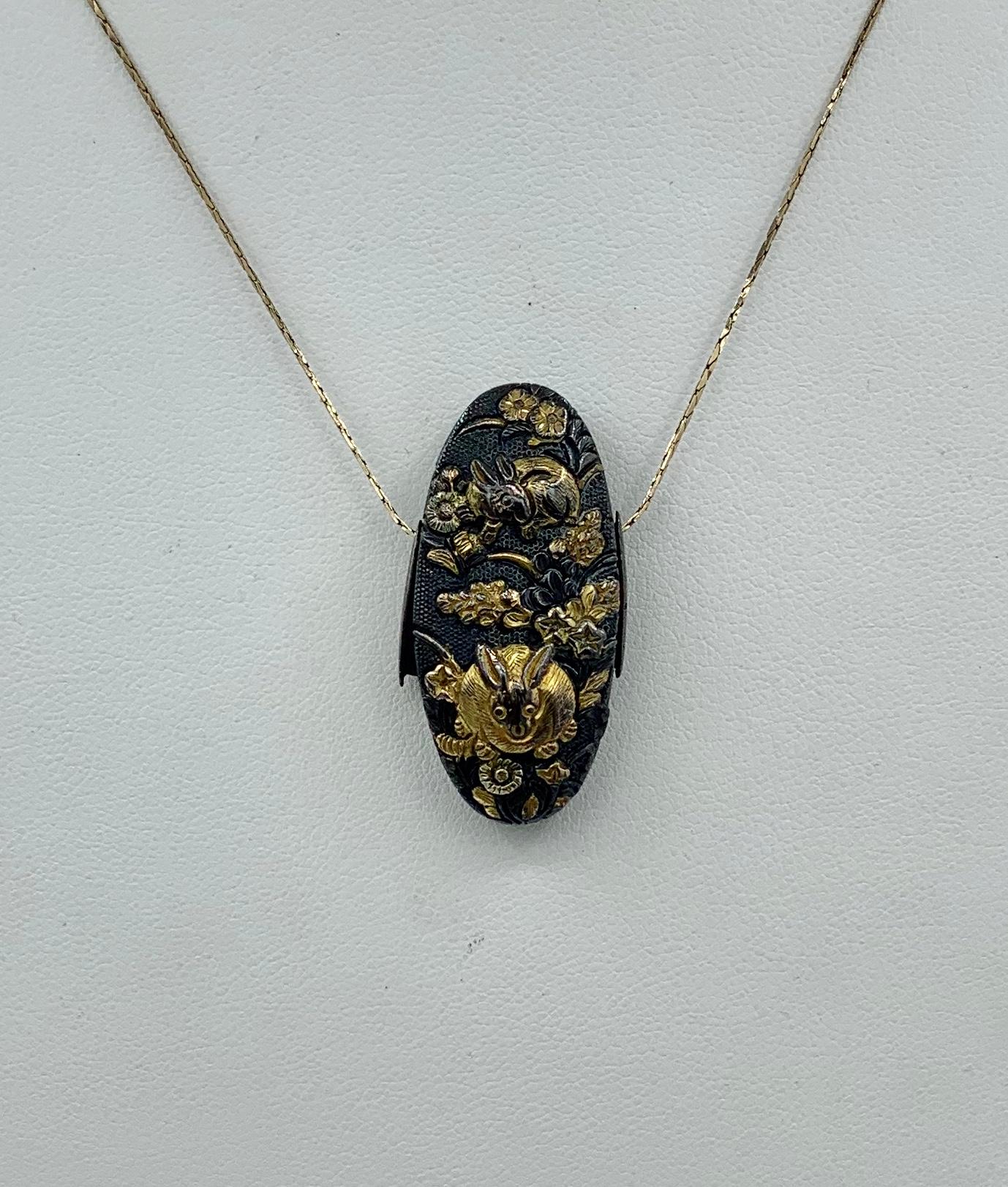 Here we have a very rare Japanese Shakudo Pendant with images of two Bunny Rabbits in a field of Flowers.  The pendant is a stunning example of Shakudo with the grace and proportion of the images and the Japanese aesthetic of asymmetry.  The rabbit