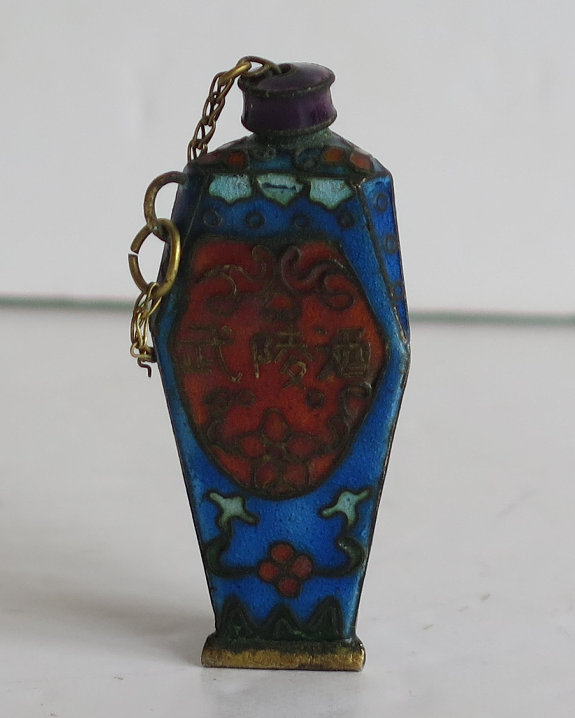 Dies ist ein sehr gutes Beispiel für eine kleine, seltene, dreieckige chinesische Schnupftabakflasche aus Cloisonné mit handemaillierter Dekoration, die verschiedene florale Motive darstellt, und mit dem originalen Kettenverschluss aus der