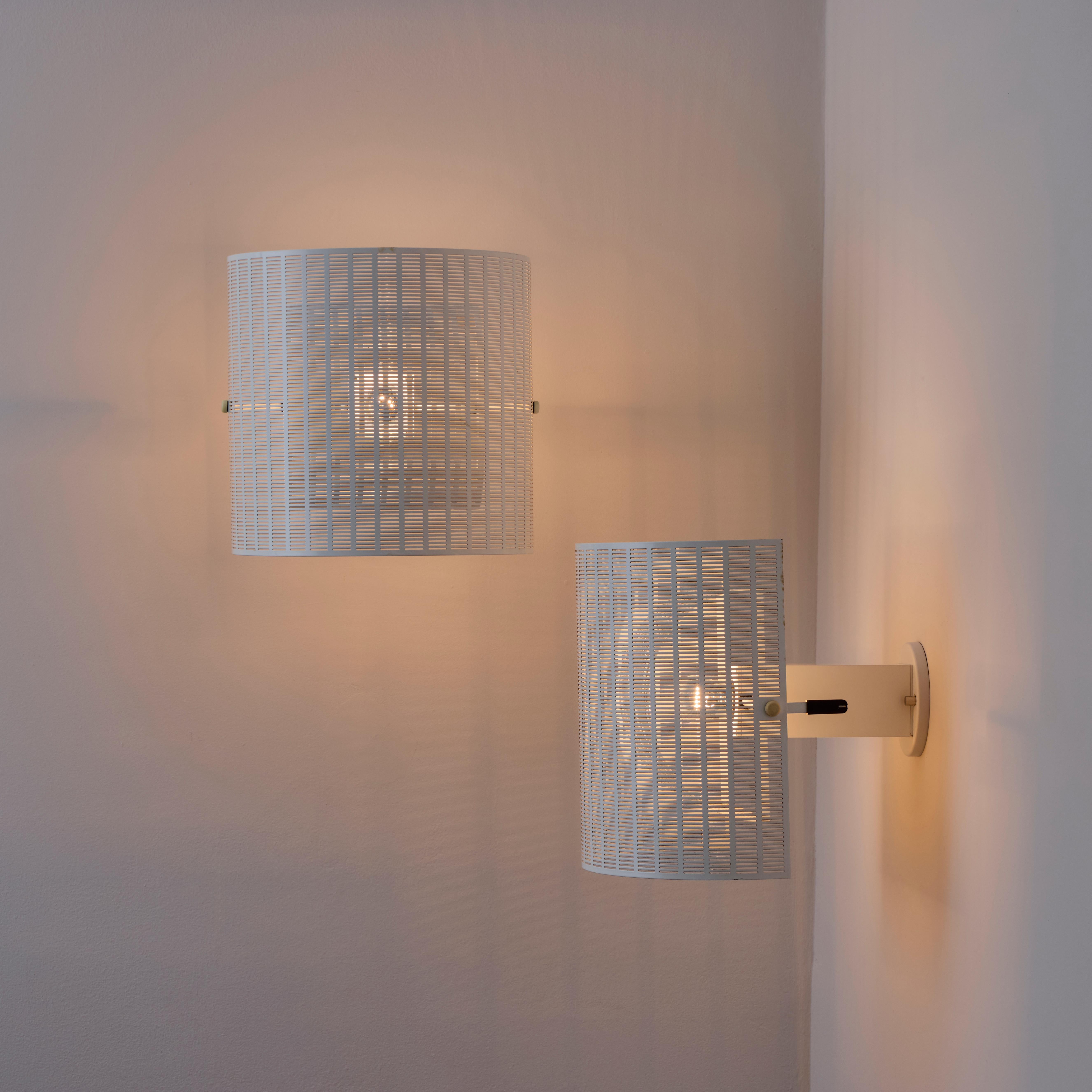 Pair of rare Shogun sconces by Mario Botta. Designed and manufactured in Italy, 1985. White powder-coated metal and plastic fitments. Both exterior and interior shades may pivot up or down for multiple articulations which in turn, affect the light