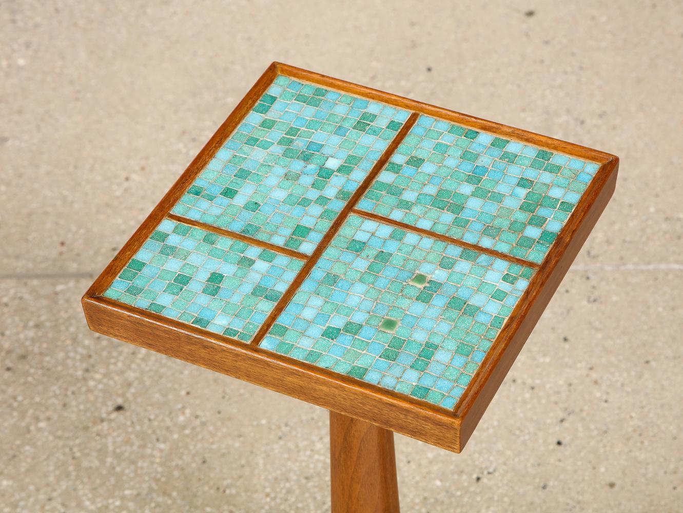 Mahogany, opaque glass tiles, brass. Green and turquoise Murano inset tile top, solid mahogany tripod base with brass feet. Makers label affixed underneath.