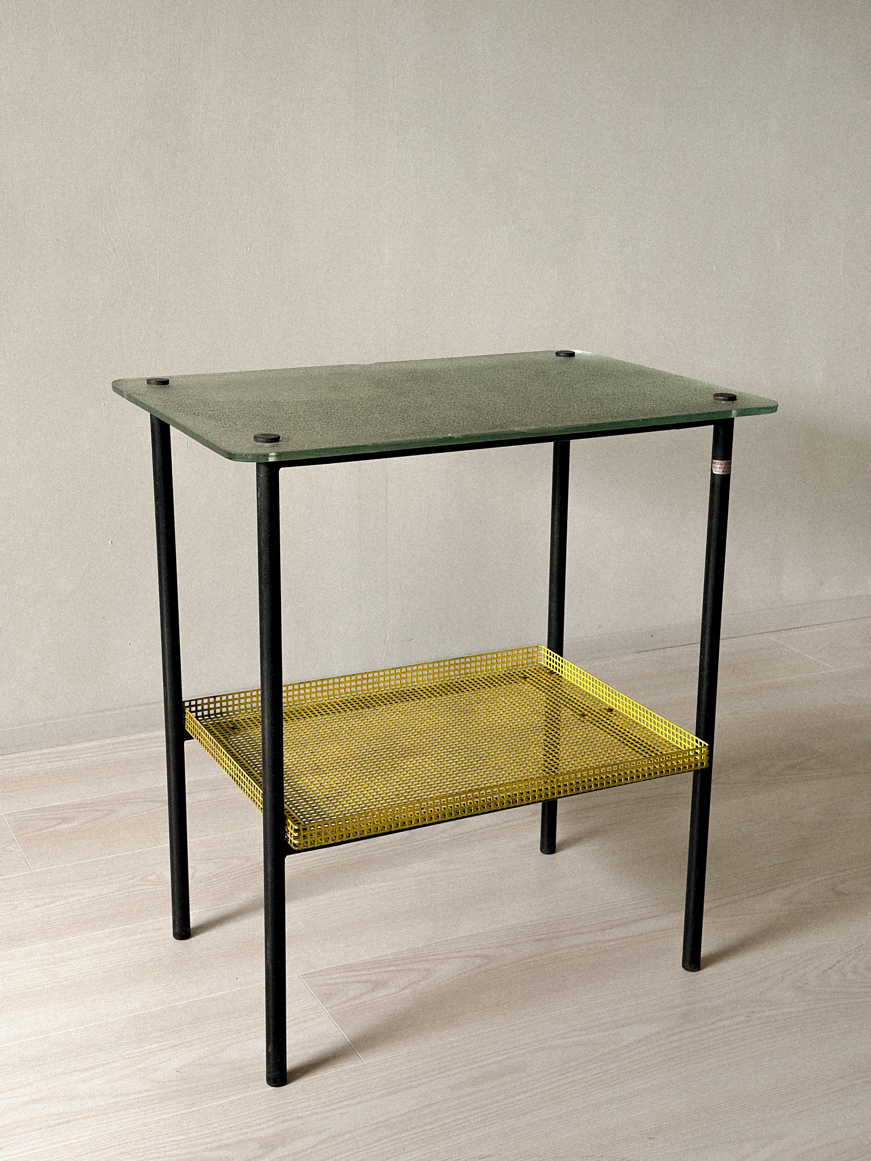 Rare table d'appoint de Paul Grivois, France, C.C.. Comprend un plateau en verre Saint-Gobain, une étagère en métal perforé laqué jaune et des pieds en métal.
Le verre est ébréché aux deux extrémités. Patine d'origine. Légère usure due à l'âge.