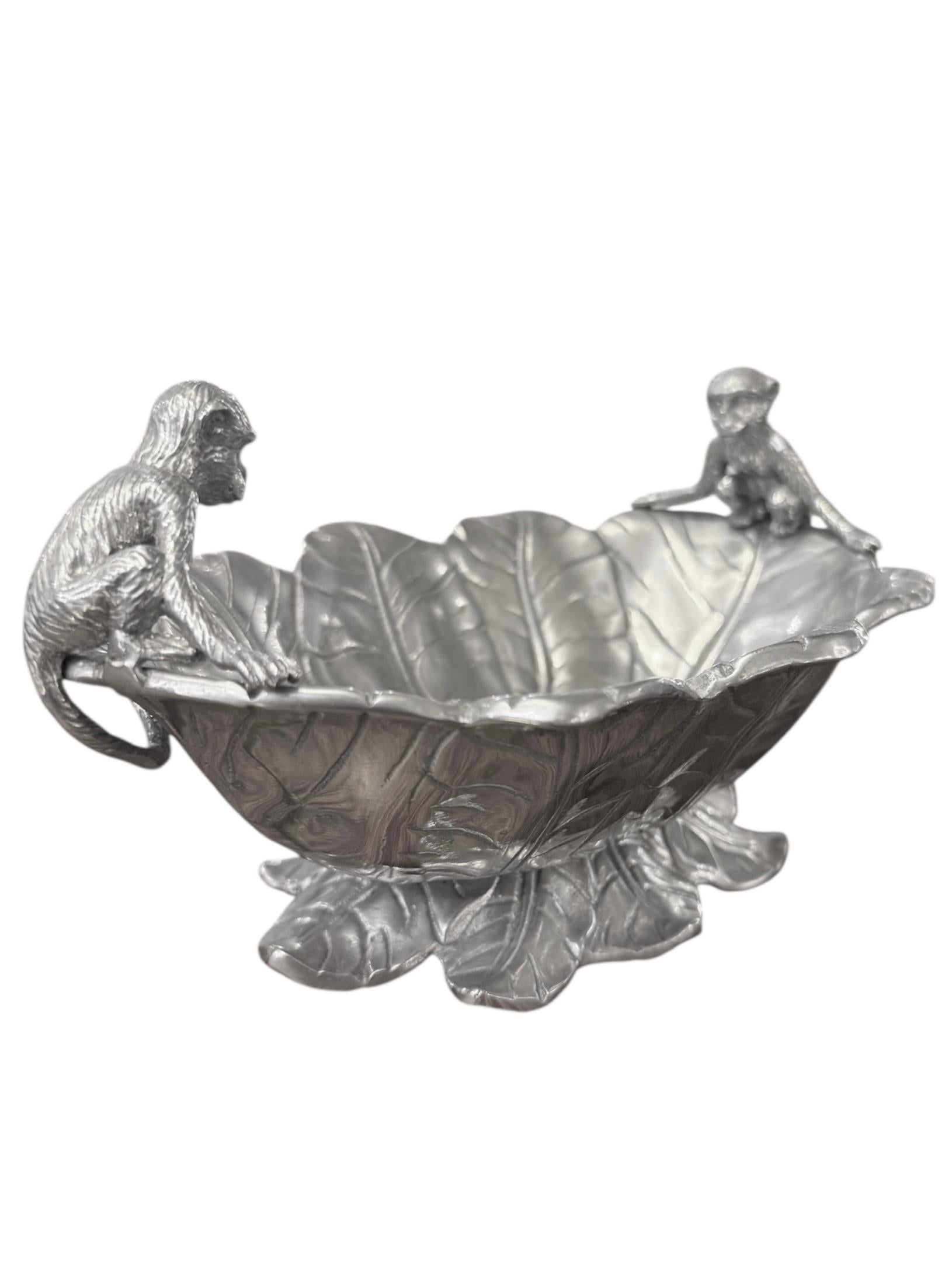 This rare and collectible piece from Arthur Court's 2005 collection showcases the brand's signature nature-inspired design. Crafted from high-quality aluminum, the bowl features an intricate banana leaf motif, with detailed monkey figures adding a
