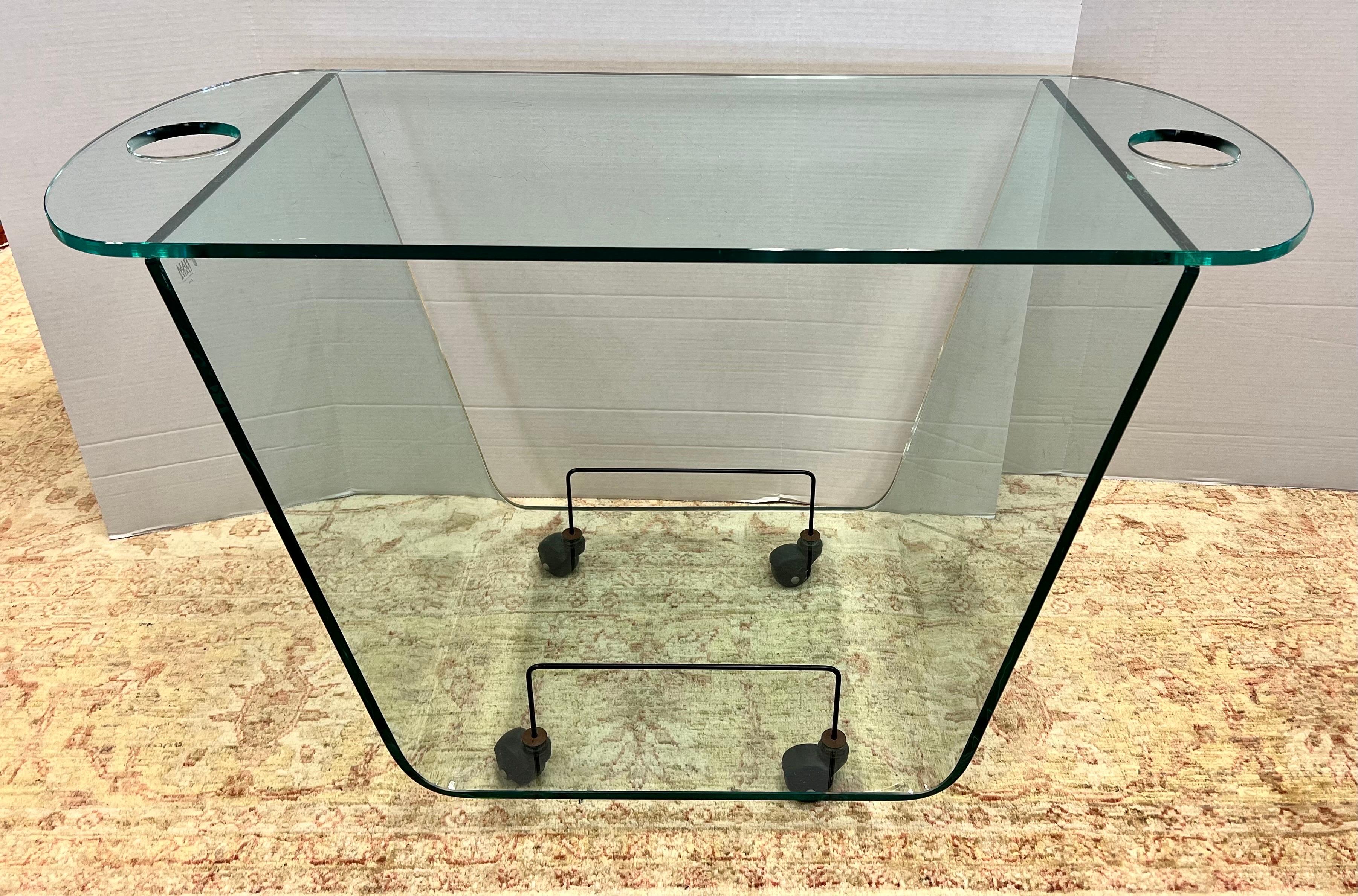 Sleek and modern and nothing short of fabulous signed Fiam, Italy rolling glass bar cart. Part of Fiam's coveted Ghost Collection. All glass save for the industrial metal casters that support it. Top is removable and has handles on the side. Signed