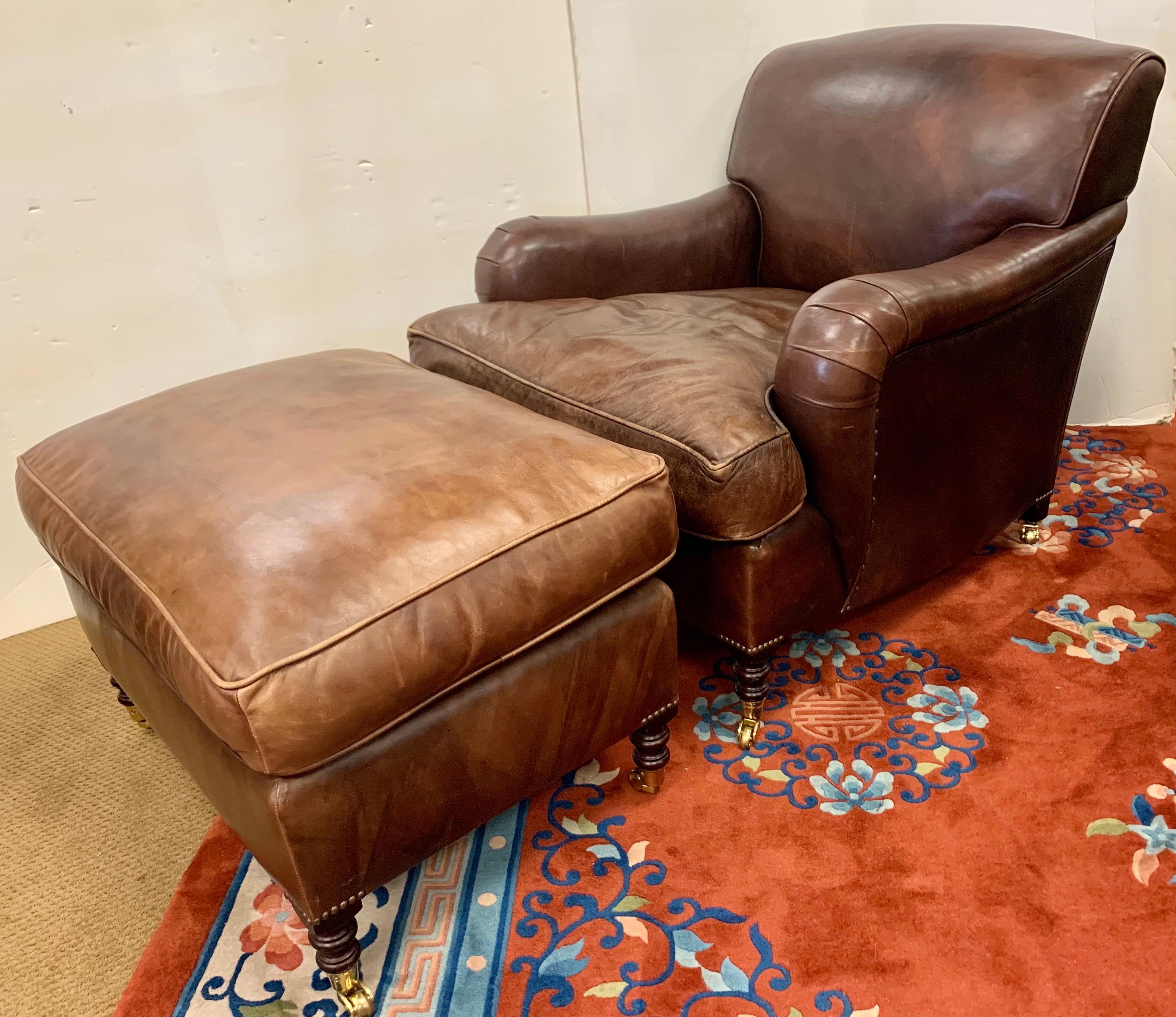 Rare to see a signed George Smith leather armchair accompanied by the matching ottoman. All tags attached. Features down-filled cushions, scrolled arms, brass nailheads and brass castors. George Smith makes some of the finest armchairs available.