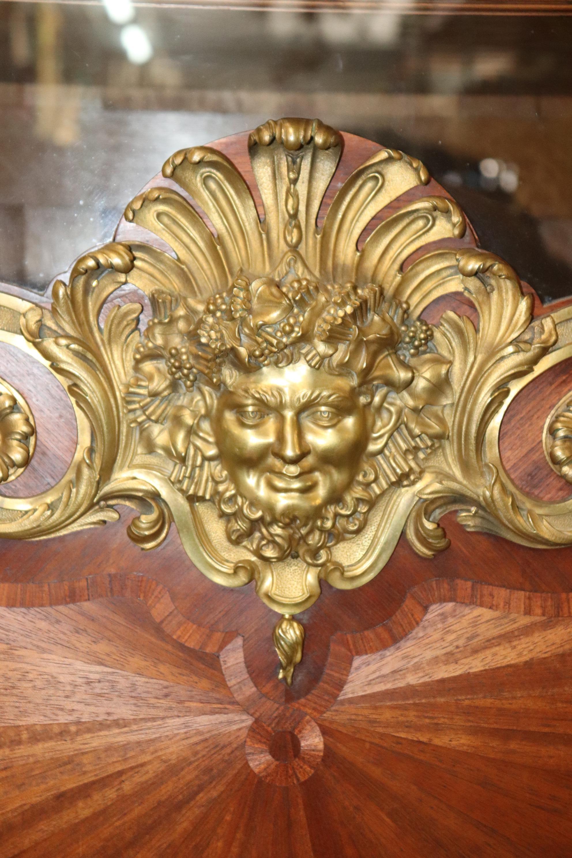 This is an incredibly rare signed Paul Sormani of Paris Vitrine for displaying silver and china in a grand dining room area. This piece features a fantastic bronze face mask and incredible reticulated bronze ormolu surmounted the piece with