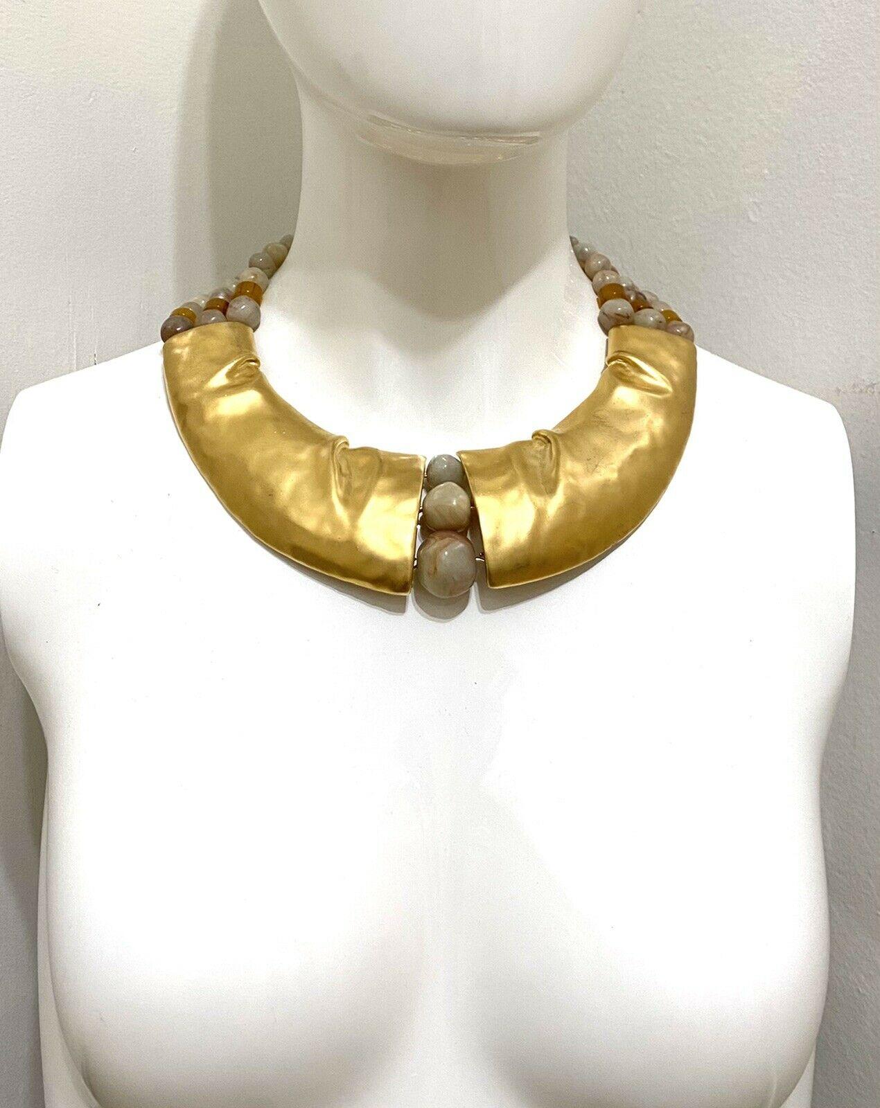 Awesome Signed Designer Trifari Modernist Golden Choker Necklace accented by 3 Strands of large Cream/Brown Lucite Beads set in Gold Gilt Mounting. Necklace measures approx. 19”l x 2”w. Signed: TRIFARI (C) on Clasp and Pendant. More Beautiful in
