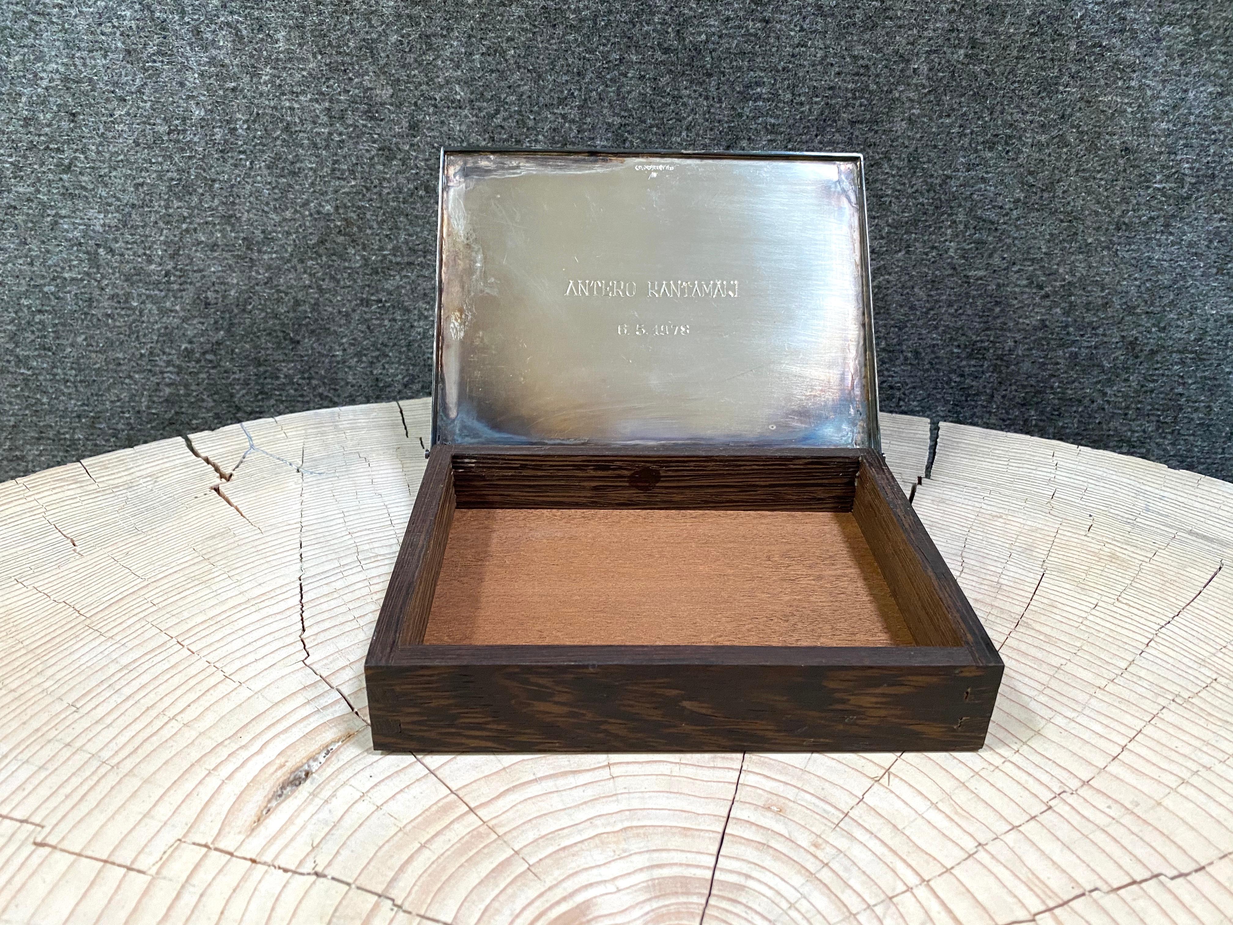 Rare Silver 830 and Teak Finland 1976 Tapio Wirkkala Tobacco Cigar Box.
These are made to order only.

Engraving on the inside, and logo engraving on the cover.
Not polished or cleaned.
Fine box with polish for direct use.

Tapio Wirkkala
