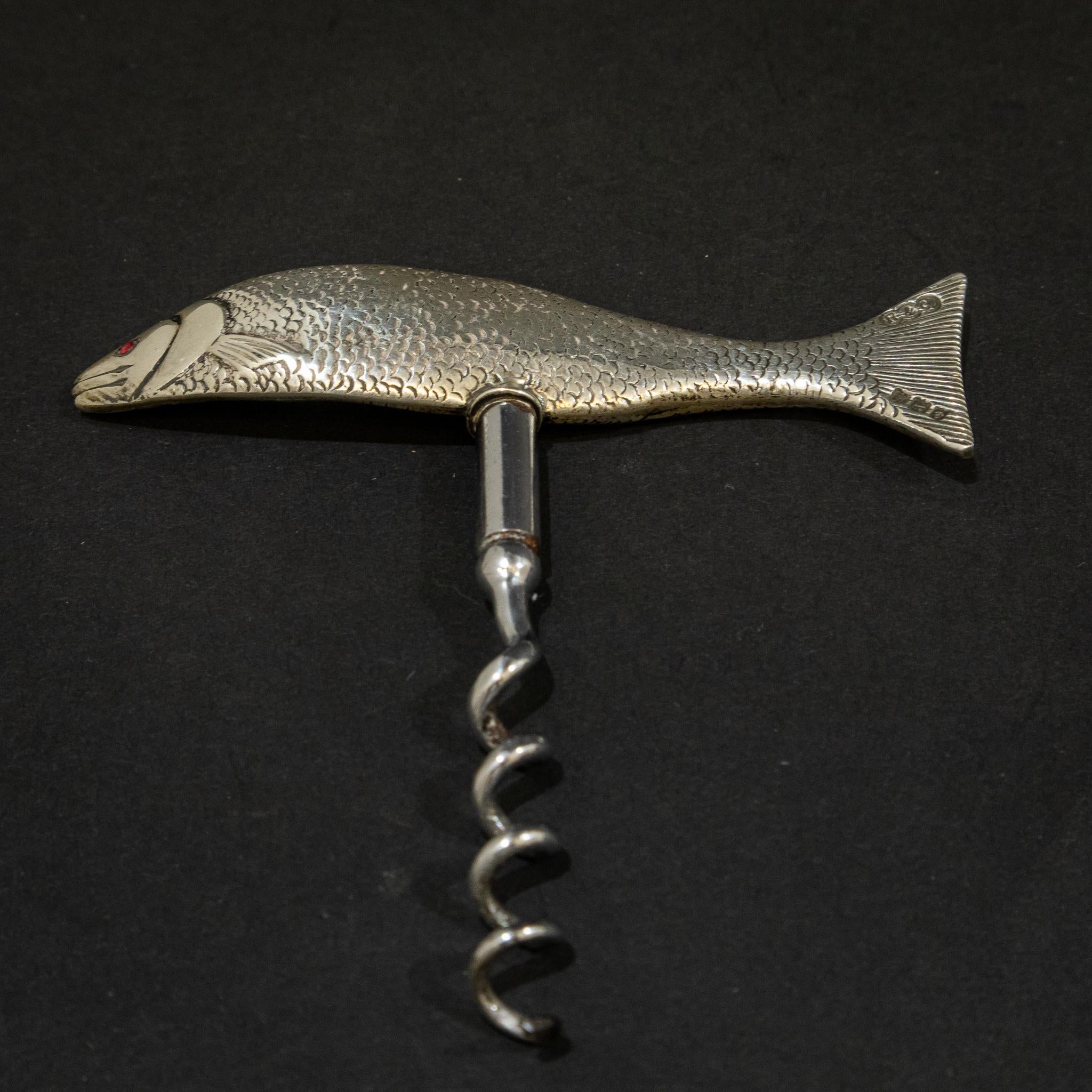 This wonderful novelty corkscrew is in the form of a fish which is made of solid sterling silver. Fine casting shows the scales and details of the fish with the body in movement and it has red jewelled eyes. It has a wonderful weight in the hand, at