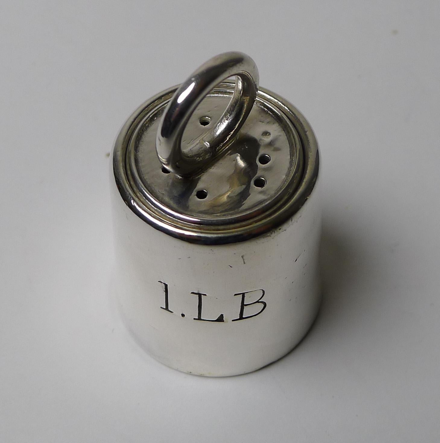 A fabulous and rare little pepper pot or pepperette by the top-notch English silversmith, Mappin and Webb.

Of course what makes this a rare piece is the it being in the form of a one pound weight . It is lovely quality to be expected by such an