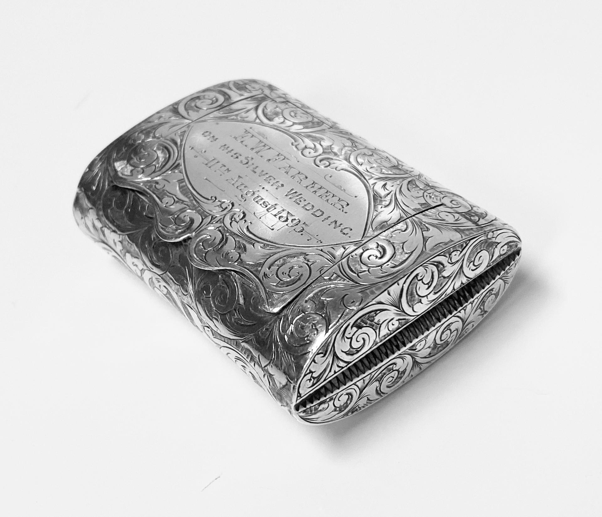 Antique Silver Vesta Case in form of clutch Purse Birmingham 1892 Thomas Hayes. The shaped ovoid form vesta richly decorated with engraved foliage, inscribed E.W.farmer on his Silver Wedding 11th August 1893. Full hallmarks to gilded interior and