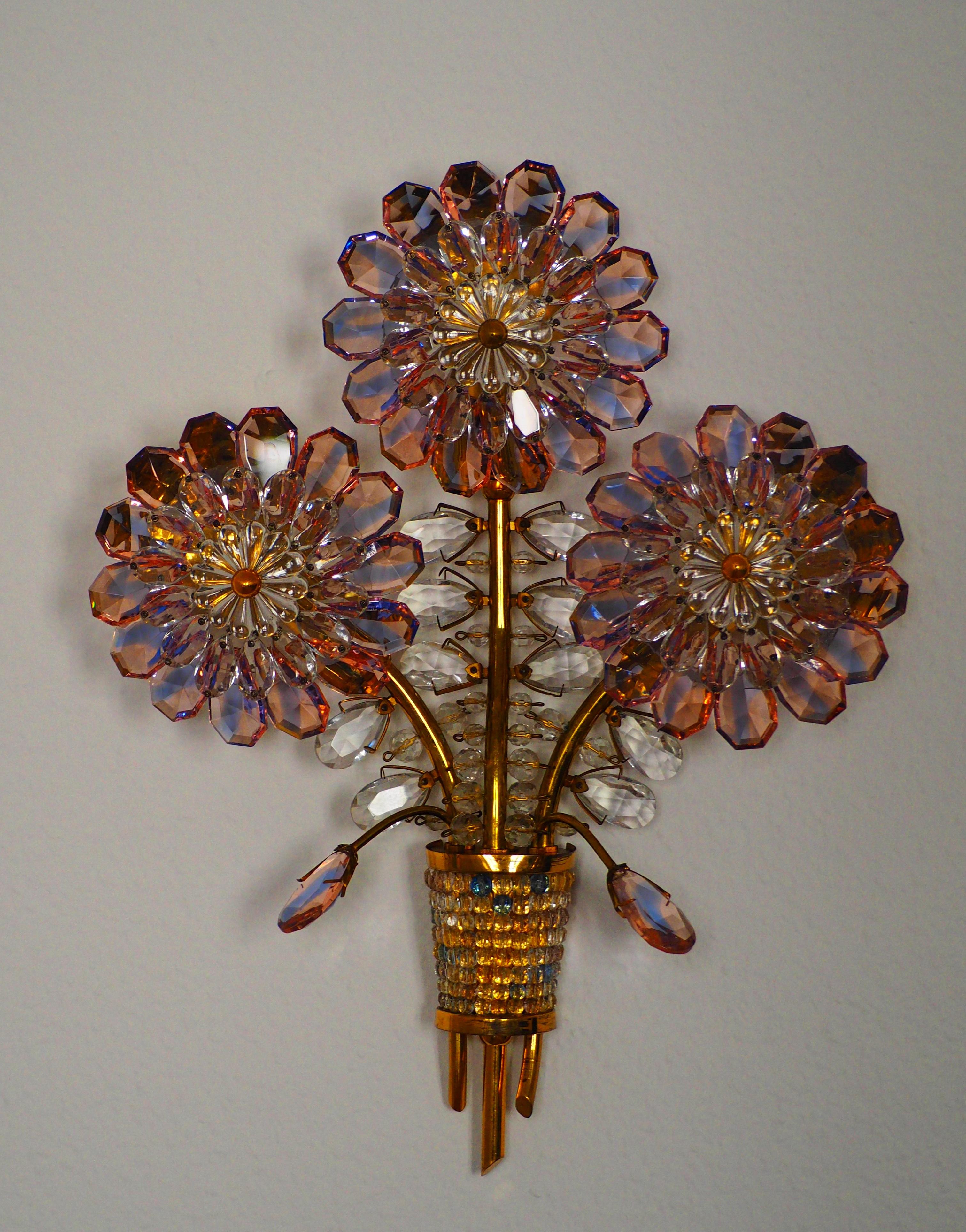 A beautiful gilt brass and crystal flower amethyst wall sconces in the style of Maison Bagues, circa 1950s.
Made of gilt brass and crystal glass, 3-light (e14 for standard screw bulbs).
 