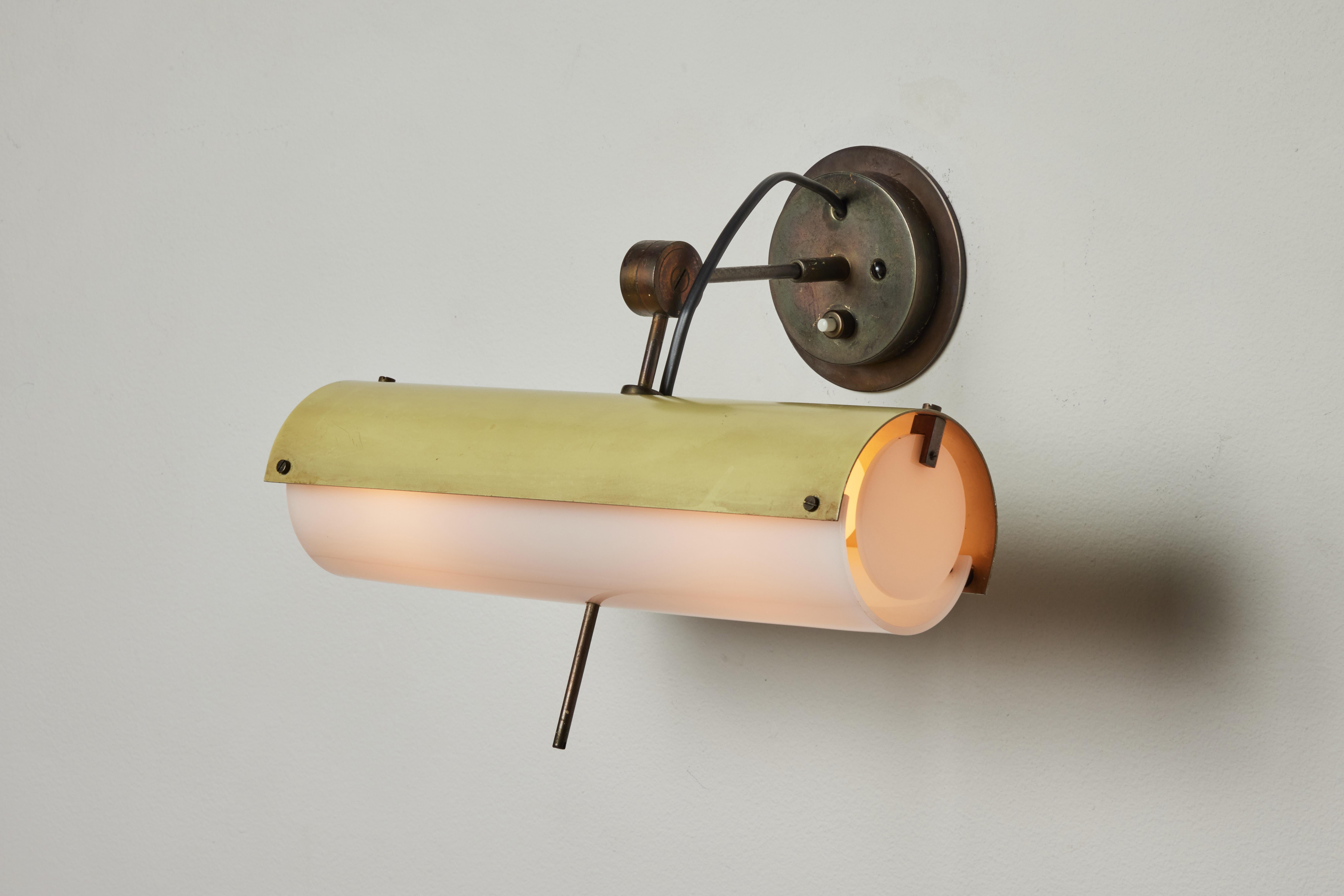 Rare single sconce by Giussepe Ostuni for Oluce. Designed and manufactured in Italy, circa 1950's. Painted metal, acrylic. Custom brass backplate. Wired for U.S. standards. Adjust positions. Takes one E27 75 w maximum bulb. Bulbs not included.