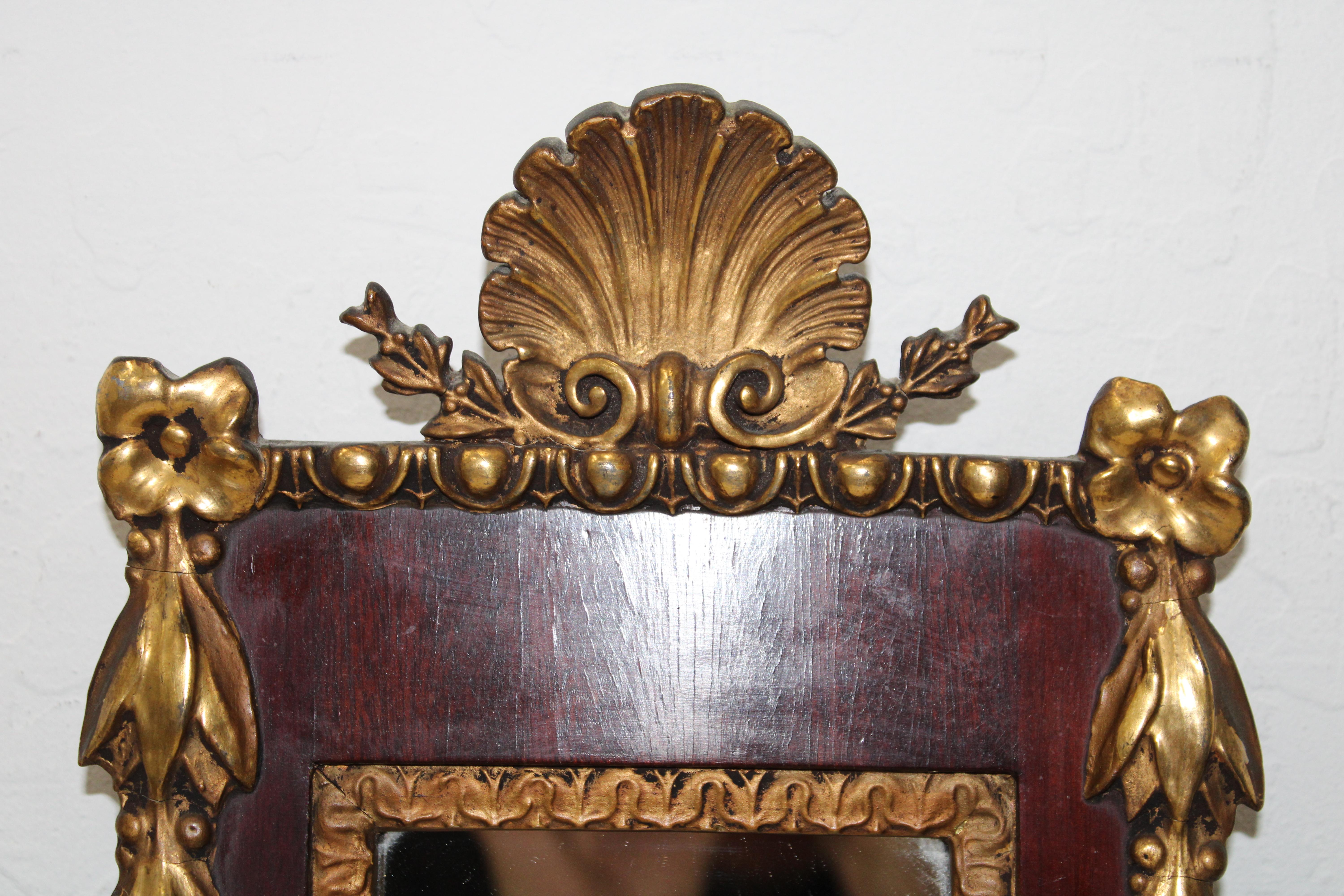 C. 19th Century

Rare sized carved & gilt, empire mirror w/ shell finial & floral decoration.