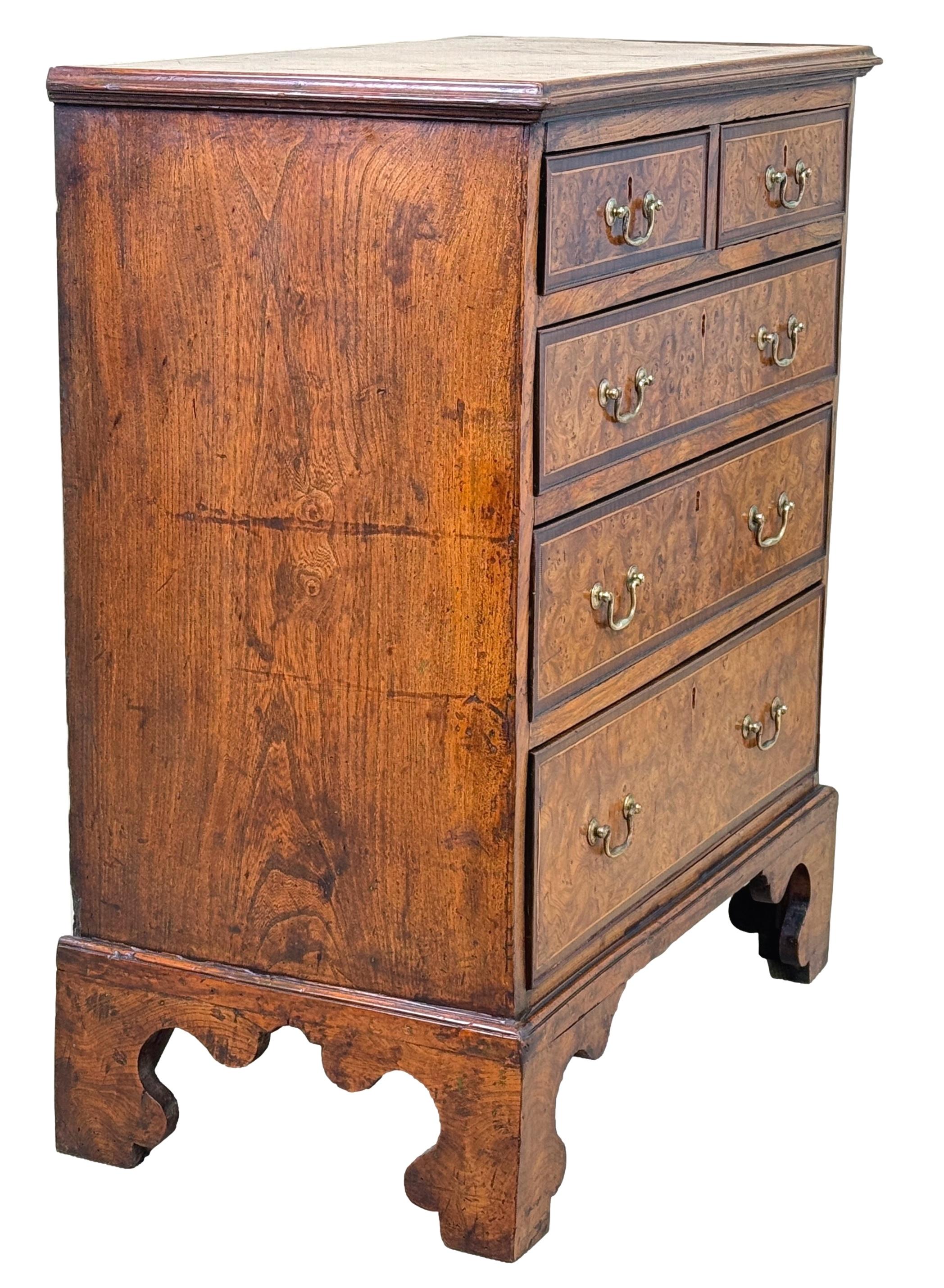 Un cassettone in radica di olmo del XVIII secolo, di epoca Giorgio III, estremamente raro e di piccole proporzioni, con un piano rettangolare superbamente modellato su due cassetti corti e tre lunghi, che conserva le maniglie originali a collo di