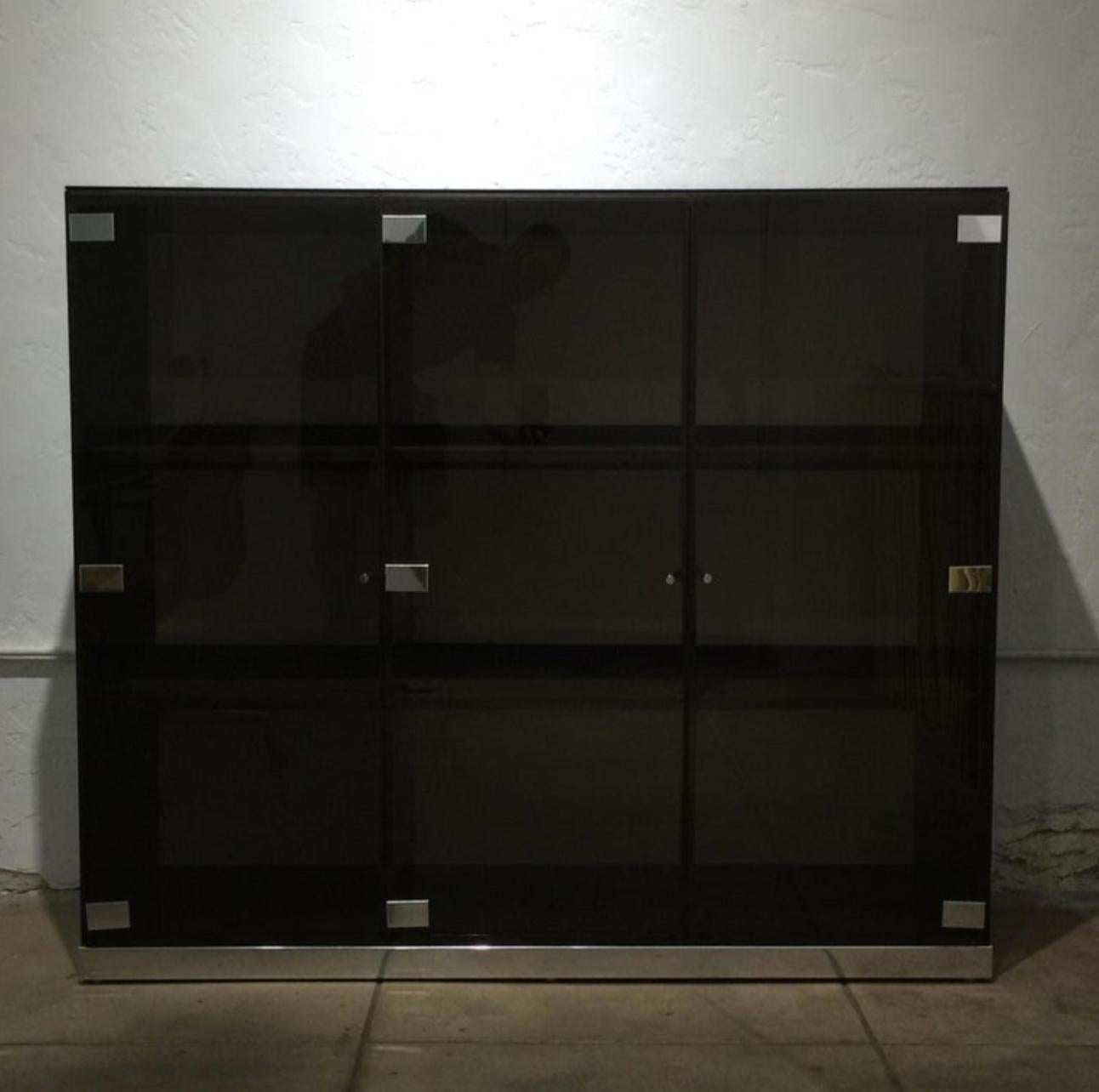 Large smoked glass and chrome cabinet or vitrine by Pierre Cardin. Three doors and six compartments. Can be backlighted (optional). A spectacular piece in any room.