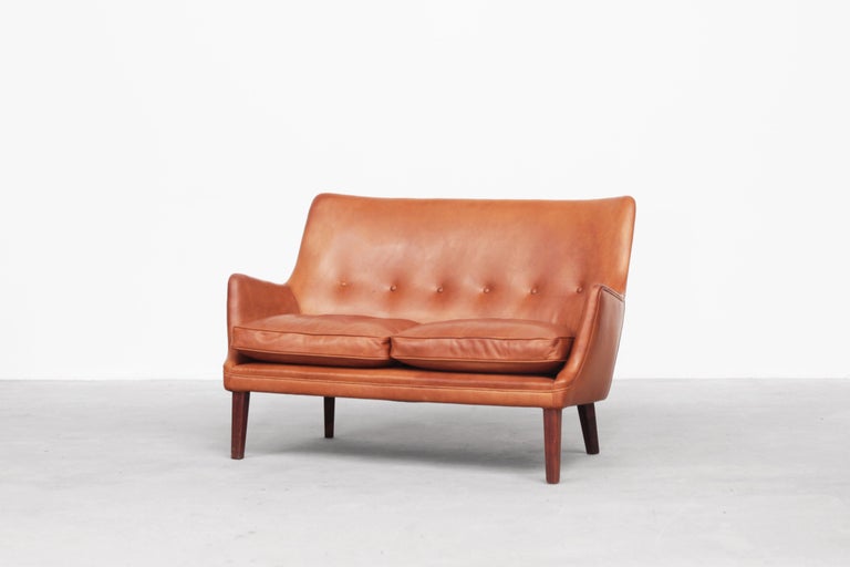 Very beautiful two-seat sofa designed by the Danish designer Arne Vodder and manufactured by Ivan Schlechter in 1953.
The sofa comes with brown-cognac leather and dark wooden legs and is in a good-excellent condition.

  


  