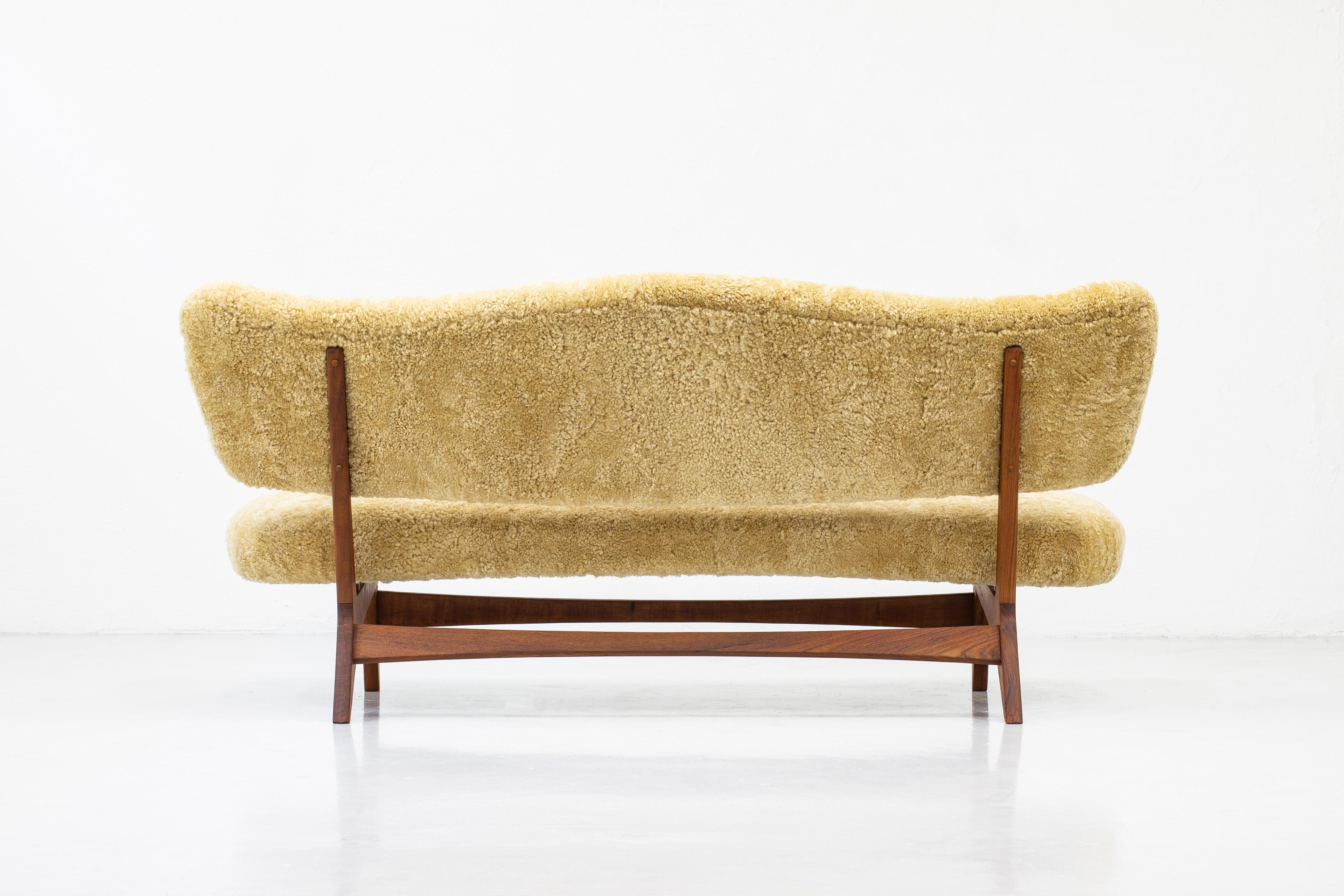 Very rare sofa designed by Norwegian Sigurd Resell for Rastad & Relling tegnekontor, ca 1952. Produced in Norway by Cabinetmakers Hjelm & Årnes around 1952-54. Made from solid teak wood in the frame and upholstered with new shearling fur in honey