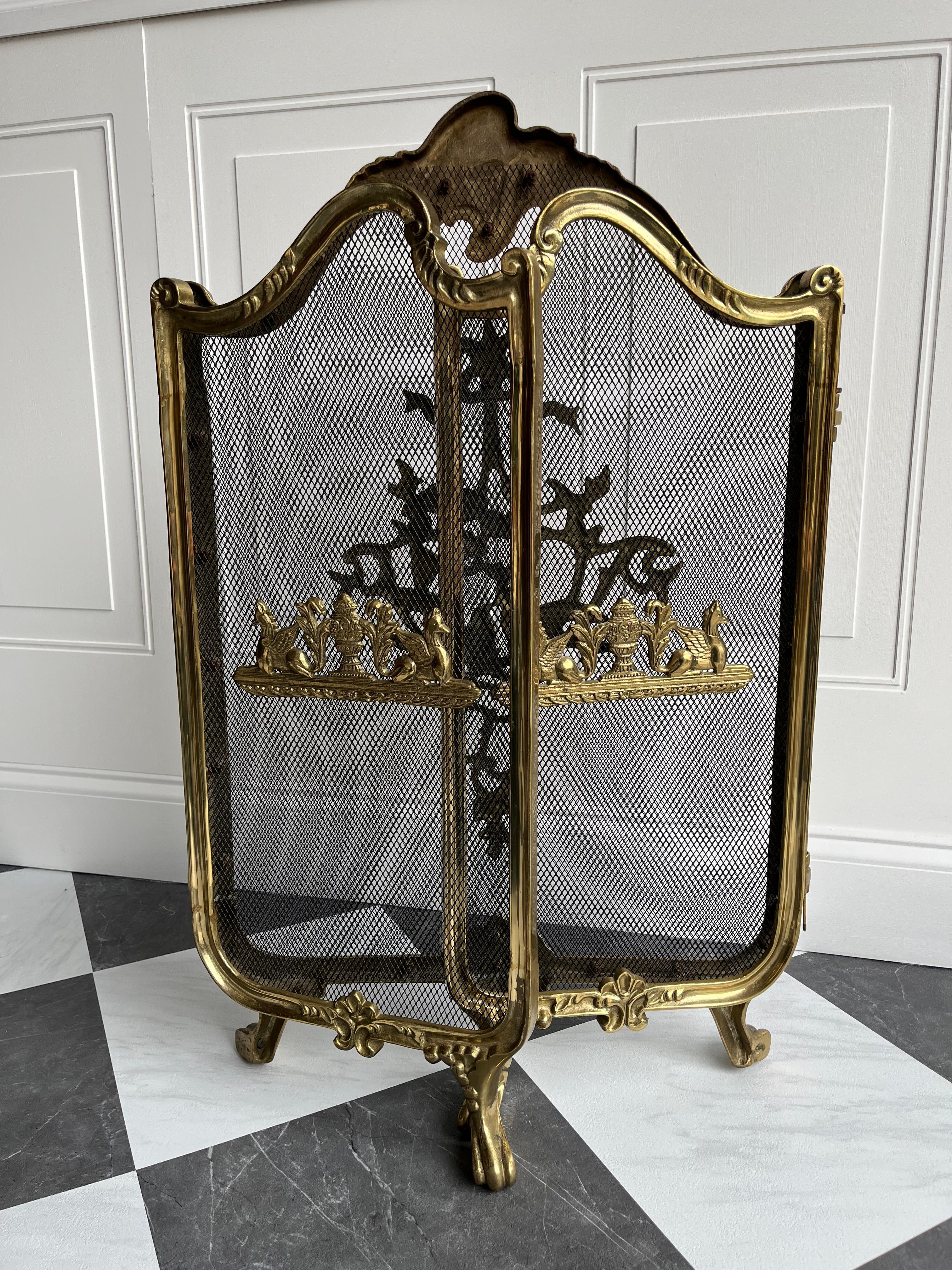 Eleva tu chimenea con la romántica elegancia de esta pantalla de chimenea tríptica de estilo rococó vintage, fabricada en la década de 1930.

Fabricada en latón macizo lacado y apoyada sobre regias patas, esta pieza es una clase magistral de