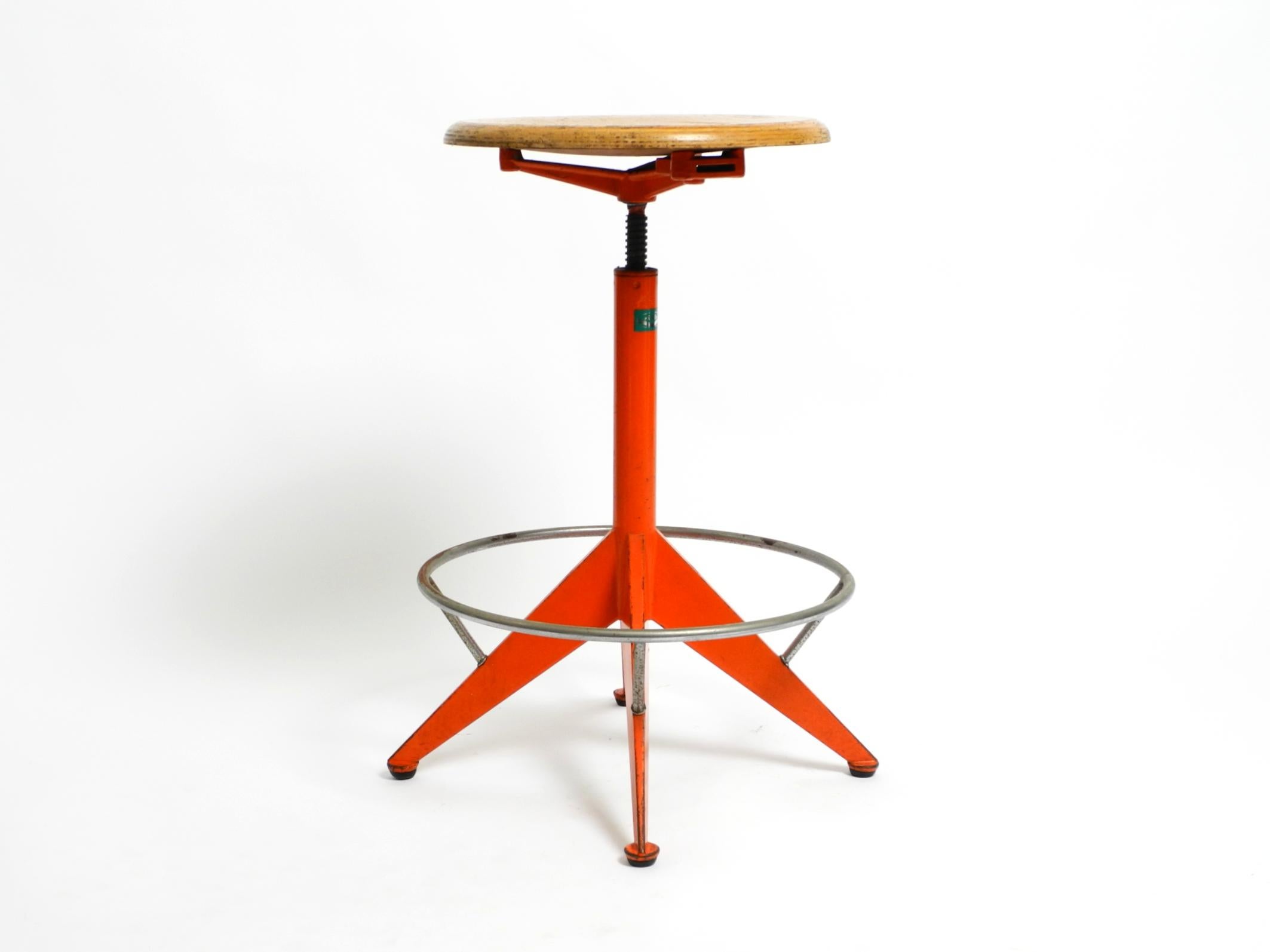 Tabouret d'atelier original du milieu du siècle en métal lourd dans sa couleur orange d'origine.
Fabricant : Mautren. Fait en Italie.
Le siège est réglable en hauteur en continu par rotation. Le repose-pieds fait tout le tour.
Le siège est en