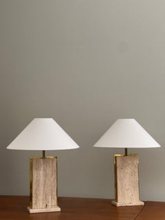 Rare solid pair of french 1970s table lamps crafted in brass and travertine.