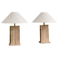 Rare solid pair of french 1970s table lamps crafted in brass and travertine.