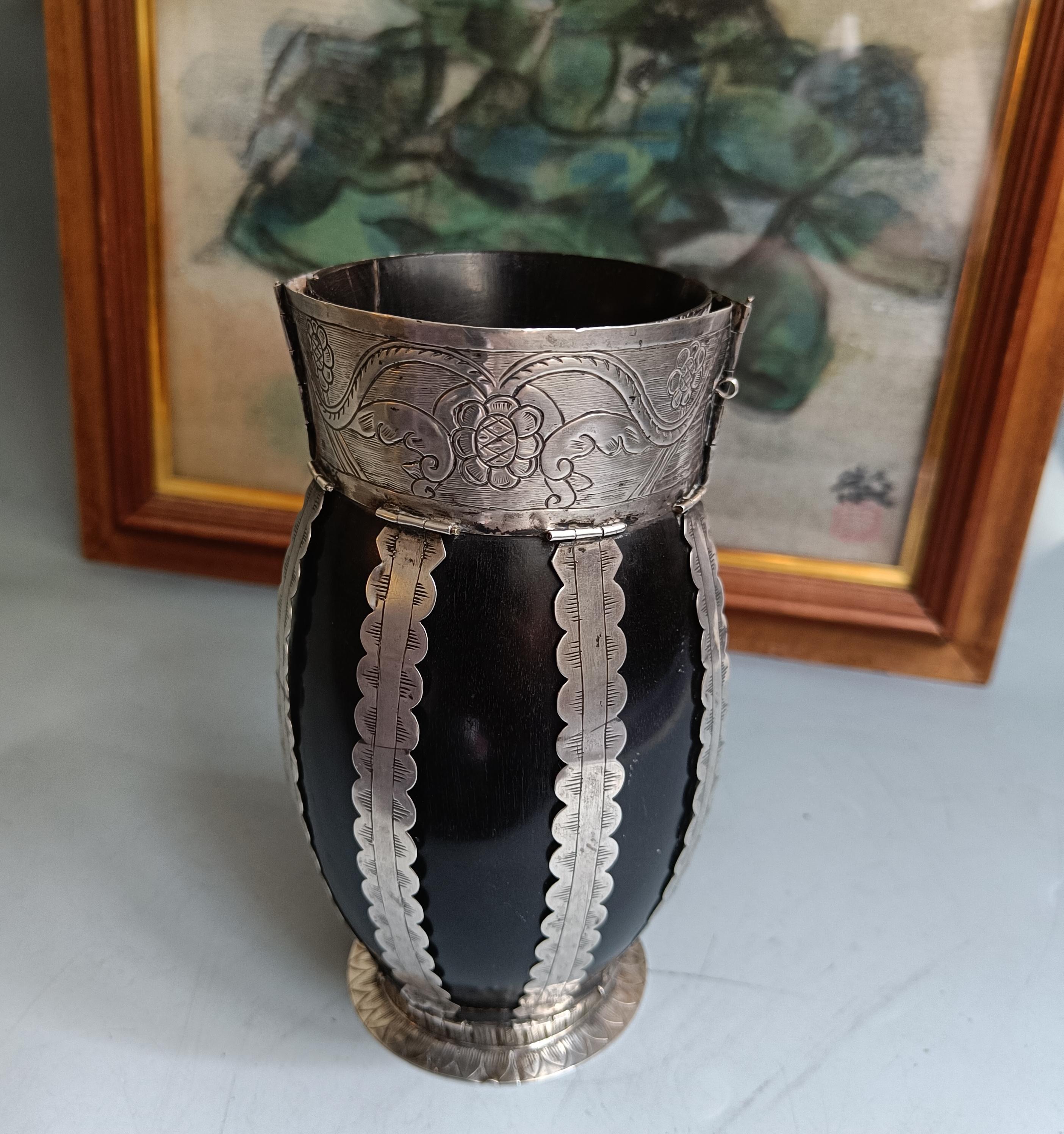 Una bella e rara tazza coloniale sudamericana in argento e legno

Una tazza da mate di epoca coloniale di ottima fattura, realizzata in legno duro scuro con eleganti decorazioni in argento. Il corpo è dotato di fasce d'argento finemente cesellate e