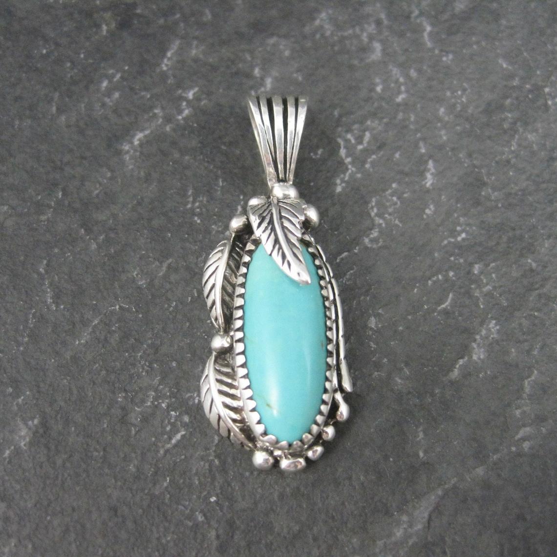 Questo splendido ciondolo è una creazione del 1996 di Carol Felley.
È in argento sterling con una gemma turchese autentica di 7x21 mm.

Misure: 5/8 per 1 9/16 pollici
Può ospitare una catena fino a 5 mm.

Marchi: Ster, 96, marchio di fabbrica di