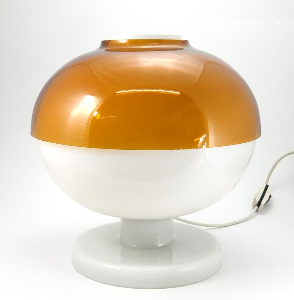 This Space Age full glass white lamp features another glass shade of amber color. It's a very rare design, and is in great condition. The whole body is glass- unfortunately the glass shade has a few minor chips.