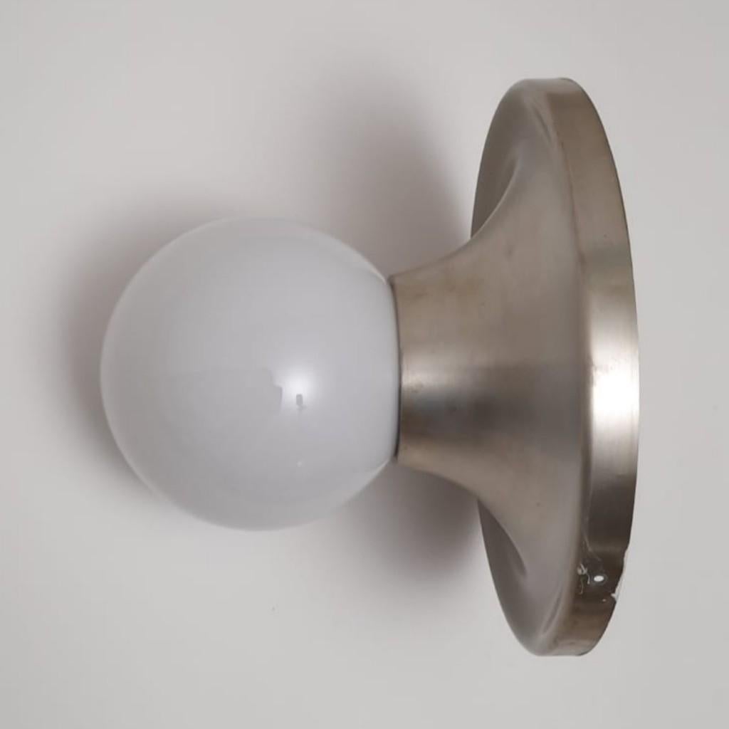 Pair of large wall lamps built by OMA Italia in the 1960s, inspired by the famous Flos light ball lamps invented by Achille and Piergiacomo Castiglioni.
These two rare lamps are handmade entirely of metal with a spherical glass envelope to hold the