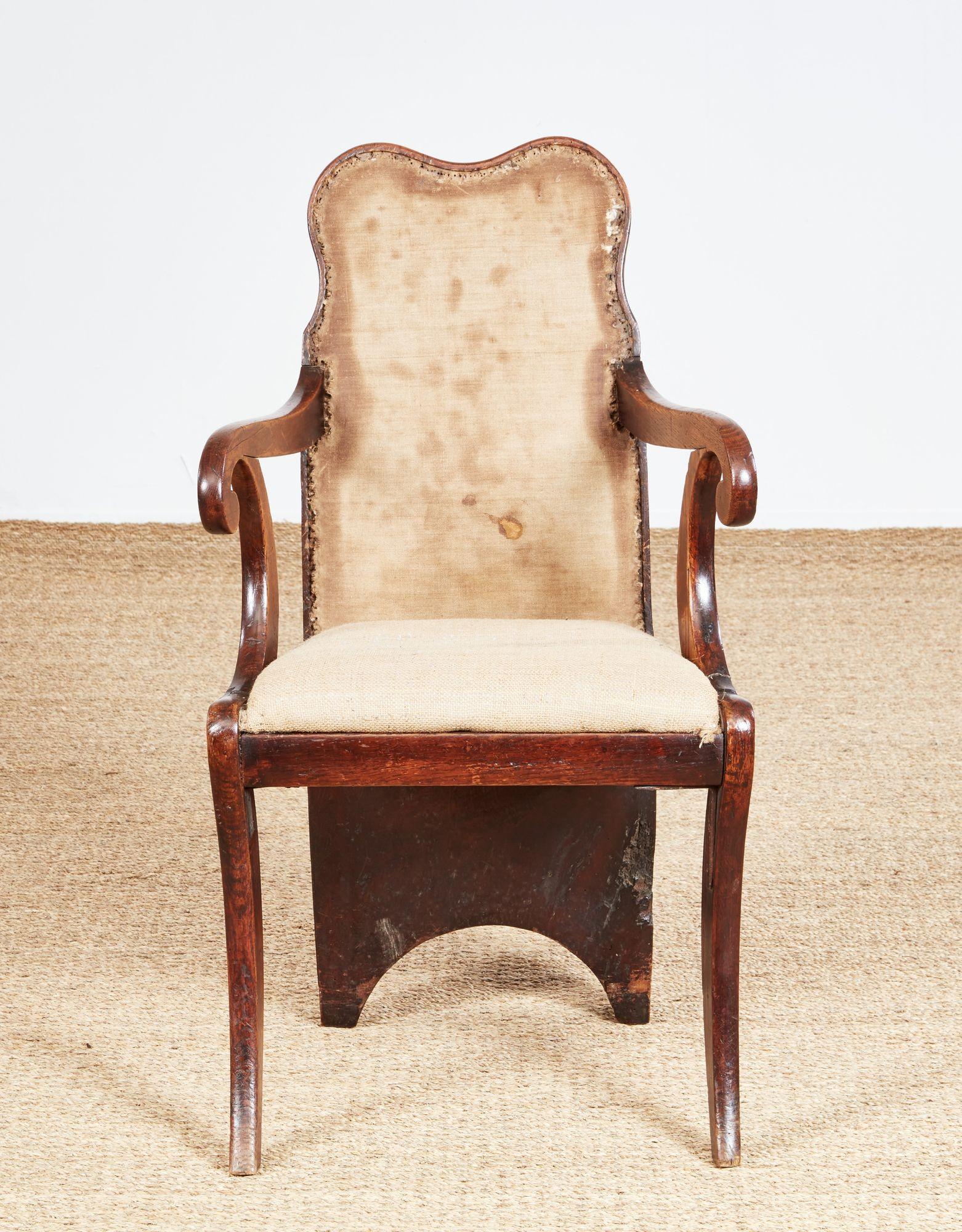 An exceptional one-of-a-kind estate-made vernacular armchair crafted to show off an ancient specimen oak burl. The front of the chair is of Regency design, with sinuous curved arms and arm supports on sabered legs, still retaining its horsehair and