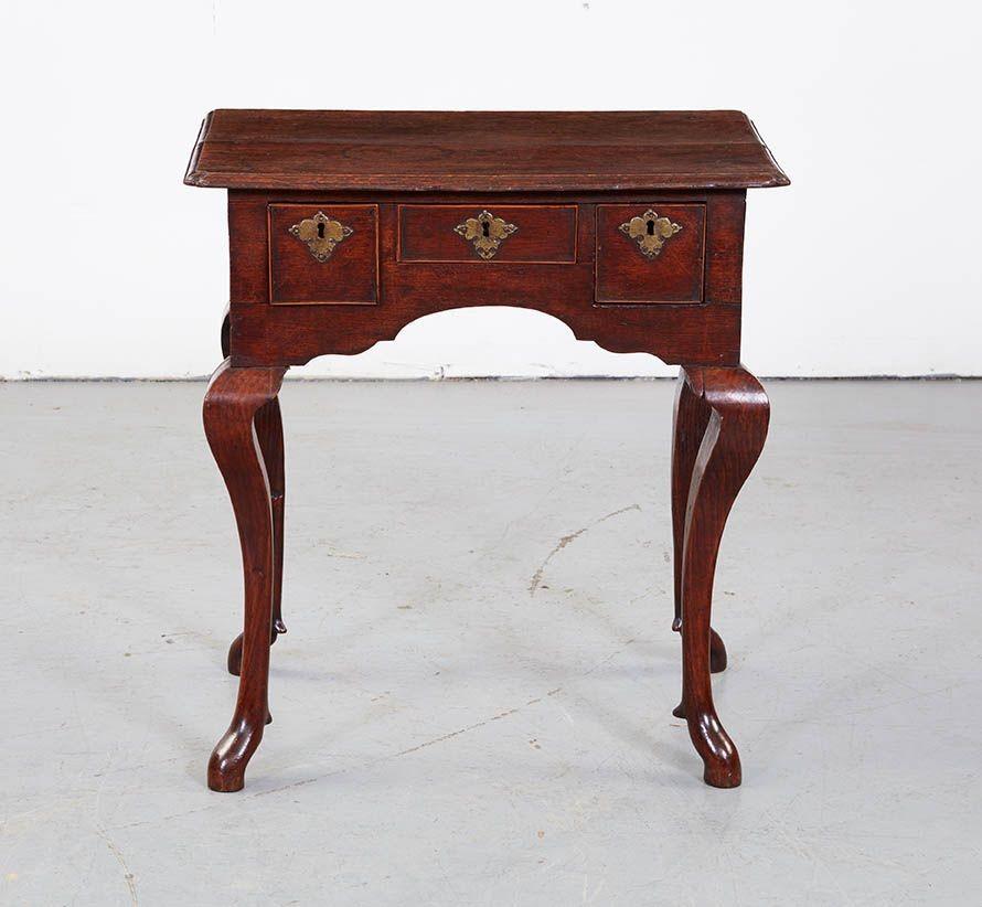 Rare early 18th century oak lowboy with a spirited stance and most unusual legs.  Beautiful and richly patinated top with thumb molded edge having reentrant 