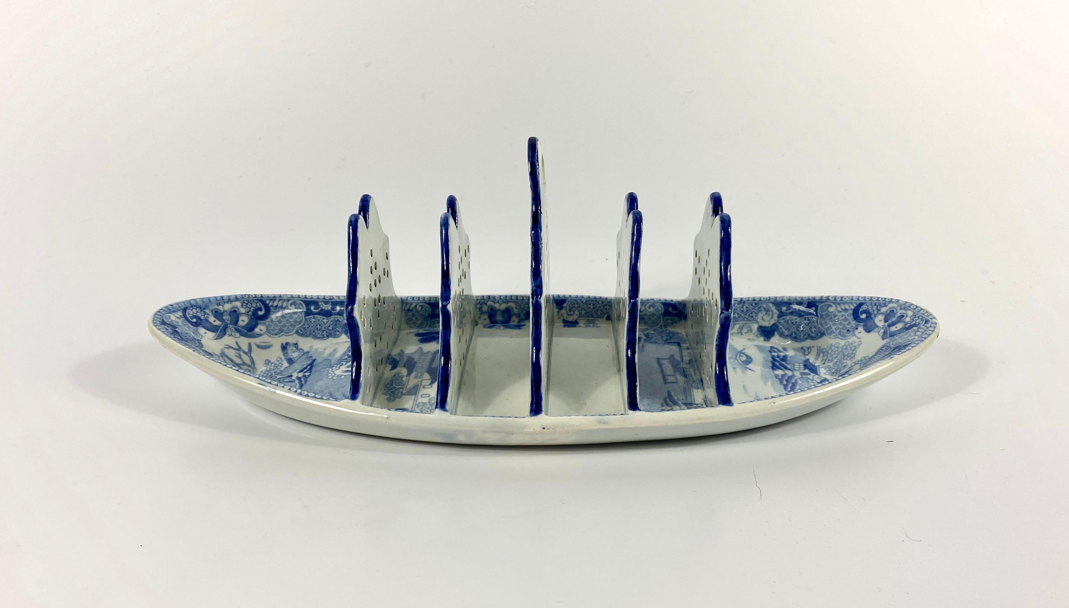 £290.00
Rare Spode pottery toast rack, circa 1820. The boat shaped toast rack, with five shaped, and pierced dividers, and printed in the ‘Willow’ pattern. All beneath a Pearlware glaze.
Printed ‘SPODE’ in underglaze blue, and impressed ‘Spode