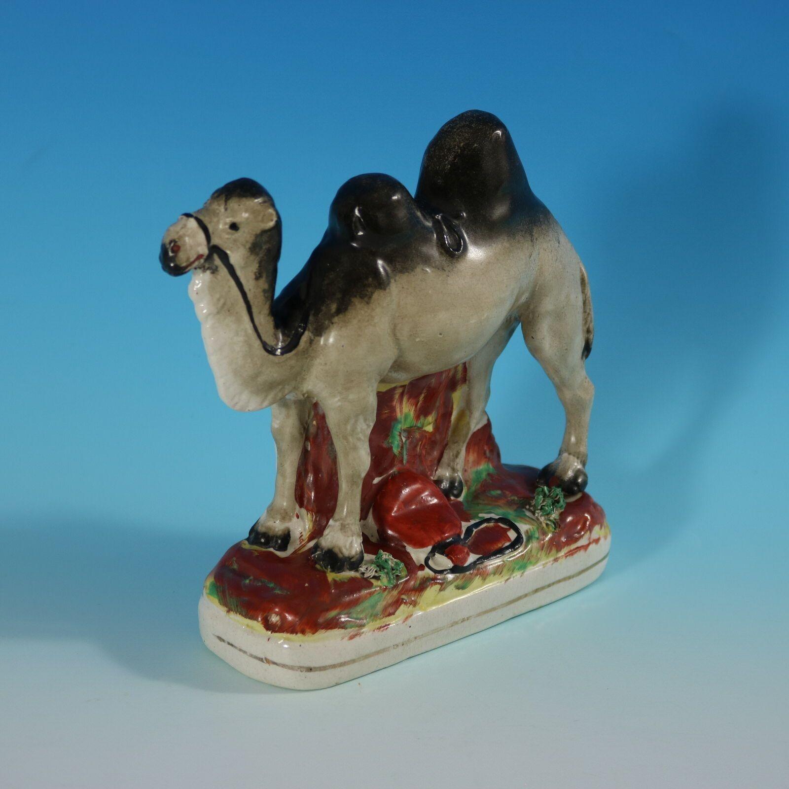 Staffordshire Pottery figure which features a Bactrian camel with a leather water bottle at its feet, stood on an oblong base. Bright gilt base line. Book reference ,'Victorian Staffordshire Figures 1835-1875' Book 3, by A.& N. Harding, page 260,