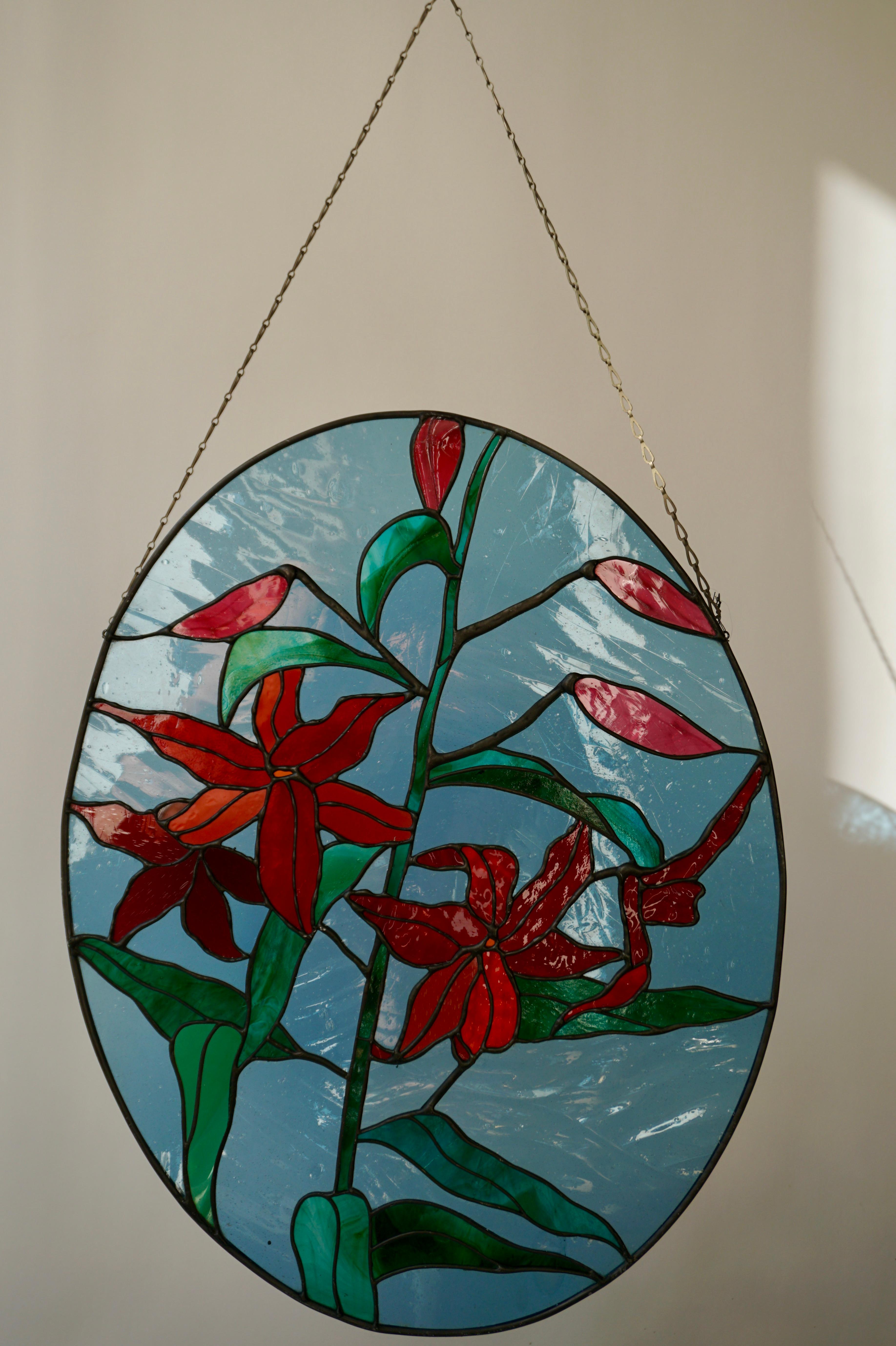 Beautiful 20th century oval stained-glass window panel with red flowers in vibrant colors.
Signed 