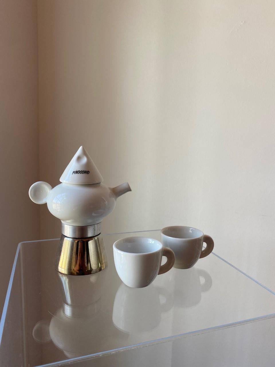 Great design on this stovetop polished steel and ceramic espresso maker, with two single cups for Espresso, circa 1990's great condition. This model is whimsical and unique. Styled after pinocchio, the piece has one ear handle with lid, styled after