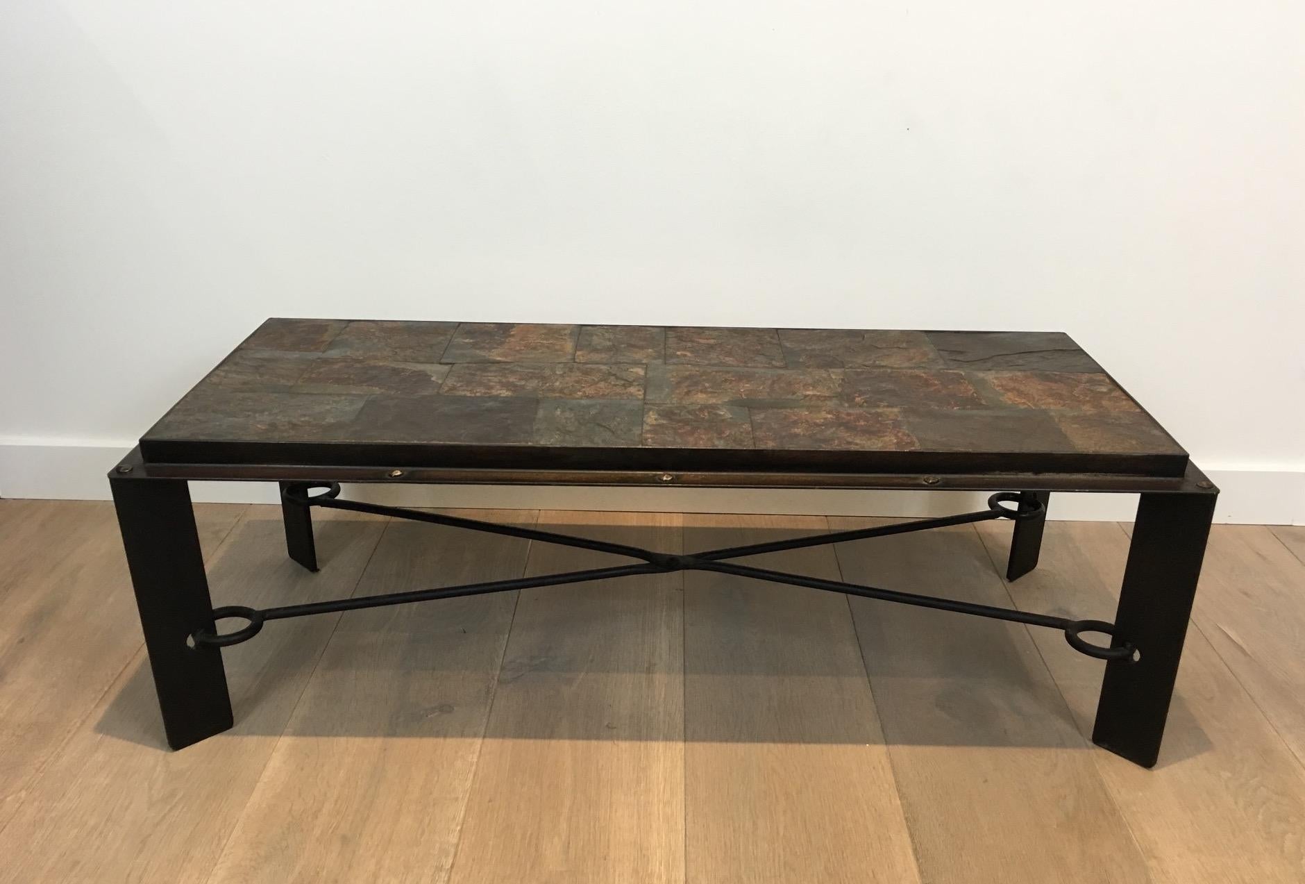 This unique coffee table is made of an interesting iron base with a cross stretcher attached to the feet with a large ring. The top is made of beautiful lava stone surrounded by a thick steel frame with large rivets. This a heavy and strong coffee
