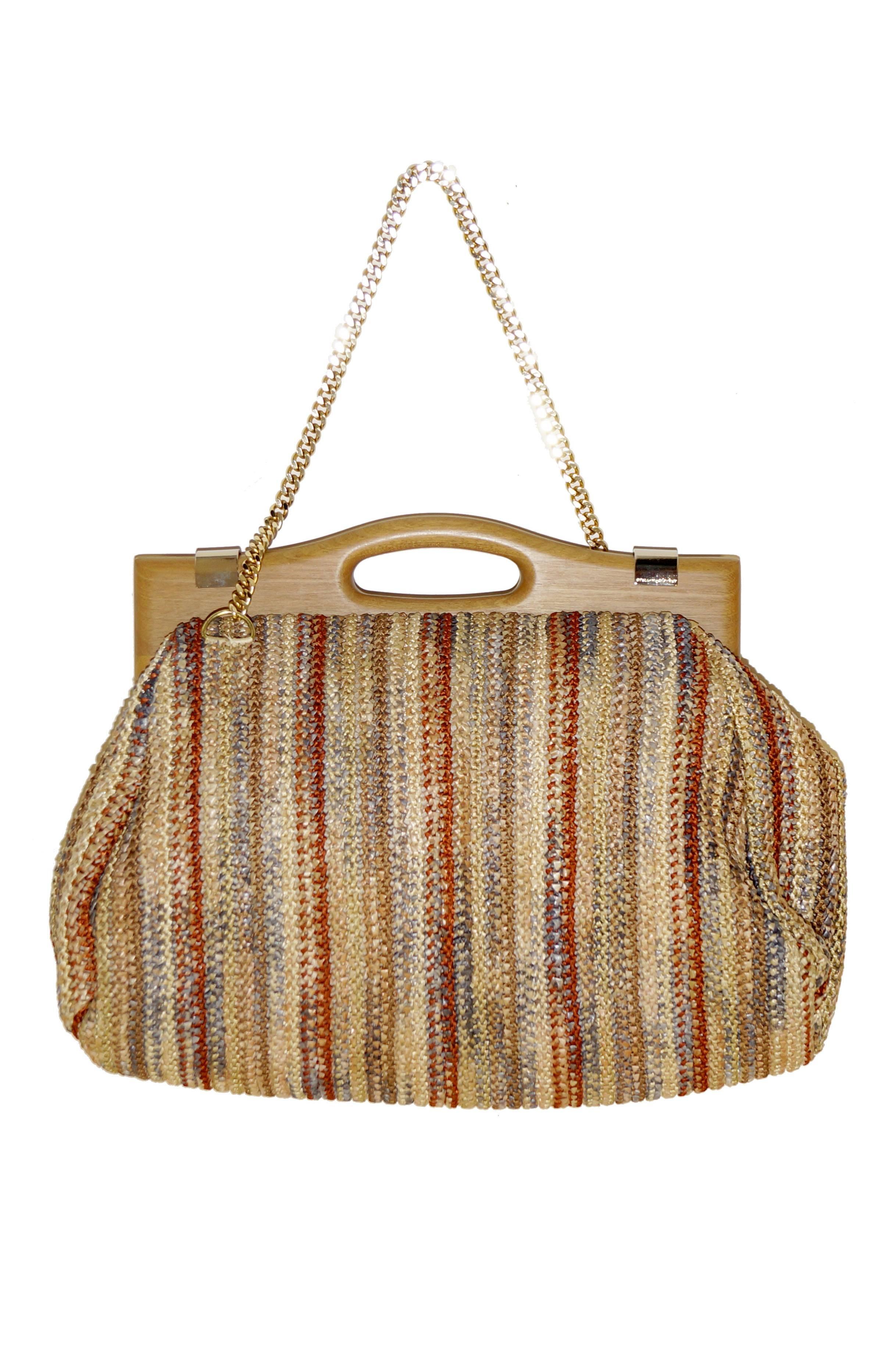 Early Stella McCartney ribbonwork handbag from late 2000s. This flexible bag has a beautiful exterior of colorful woven silk and synthetic raffia ribbons, with a wooden top handle and gold chain shoulder strap. The large interior pocket and