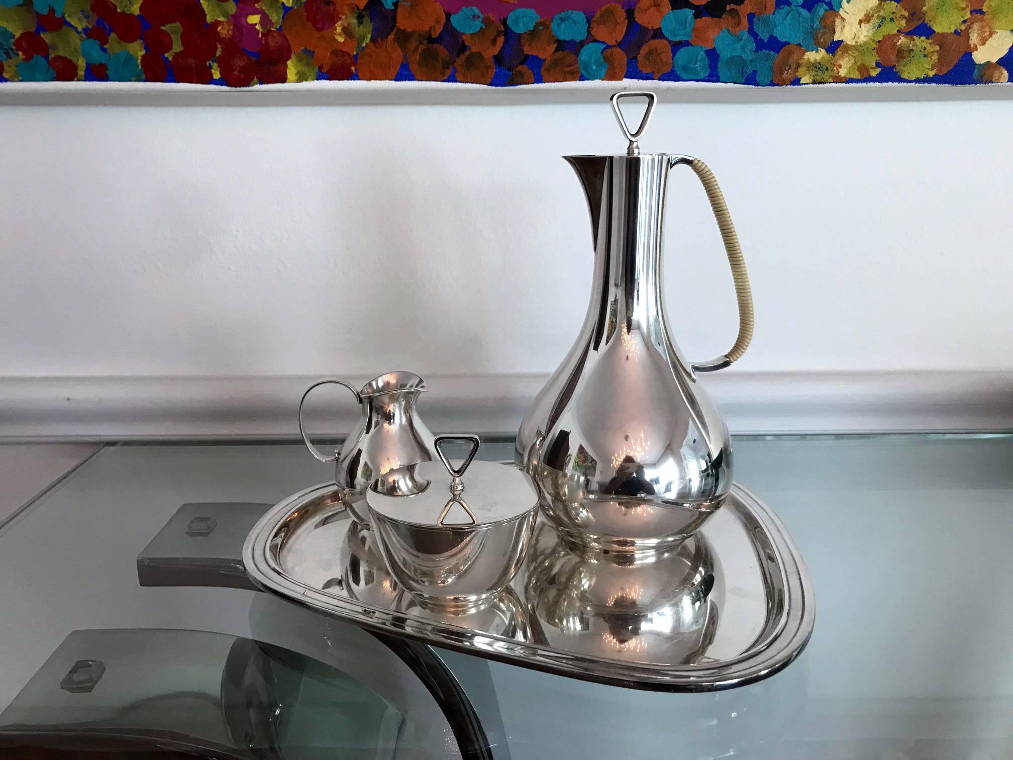 A Mid-Century Modernist coffee or tea service in sterling silver designed by Sigvard Bernadotte for Georg Jensen, circa 1950s. The service consists of four pieces, a coffee pot, a creamer, a sugar and an organically shaped tray, all marked
