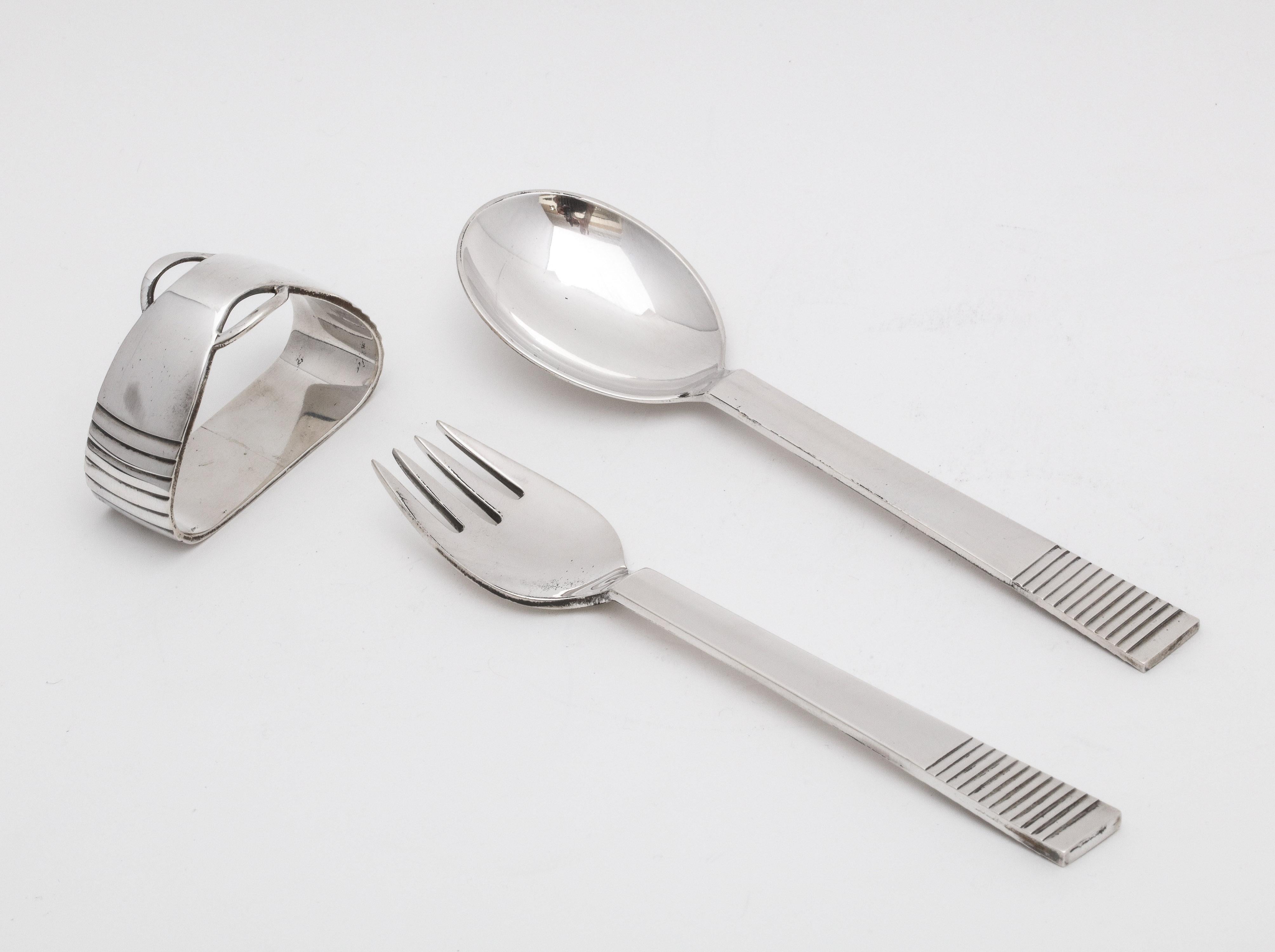 Rare, midcentury, sterling silver three-piece child's set, Denmark, circa 1940s. Pattern is parallel. Set consists of a napkin ring (hallmarked with the Georg Jensen hallmark and designed for Georg Jensen by Gustav Pedersen) and a fork and spoon (in