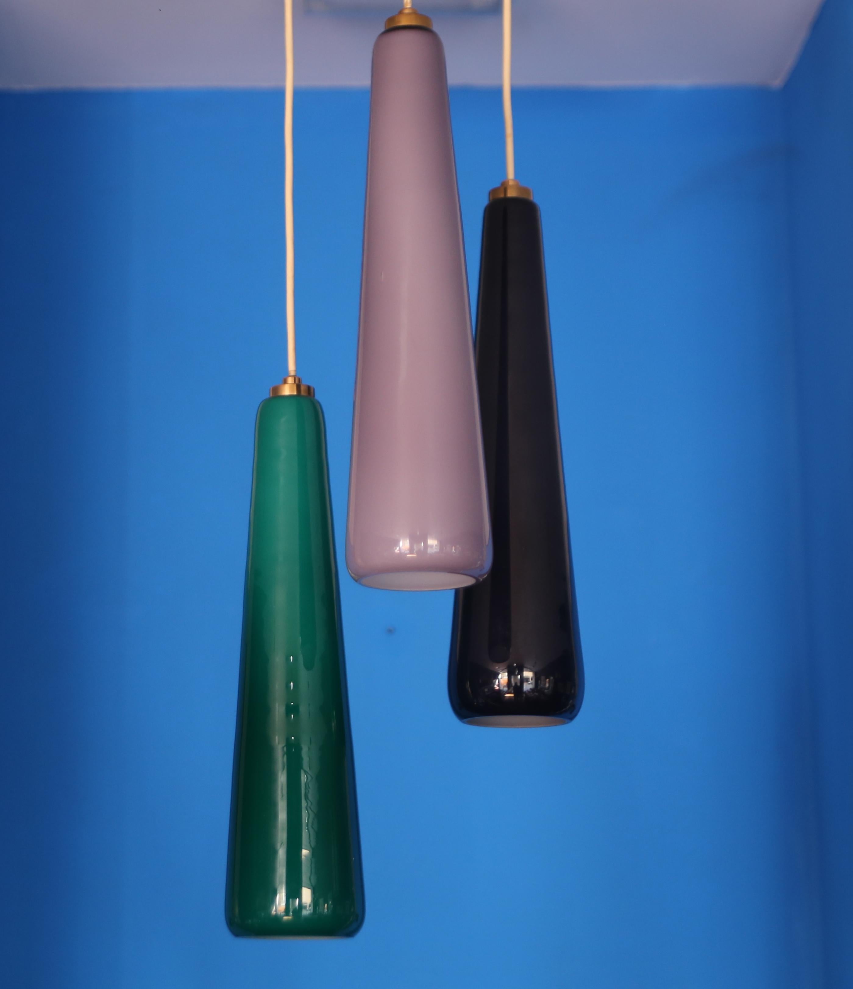 Rare lampe suspendue Stilnovo en laiton, diffuseurs en  verre coloré de Murano 1950.
Cette suspension est composée de trois verres de Murano de 50 cm chacun, d'un verre supplémentaire et marquée de la décalcomanie Stilnovo,