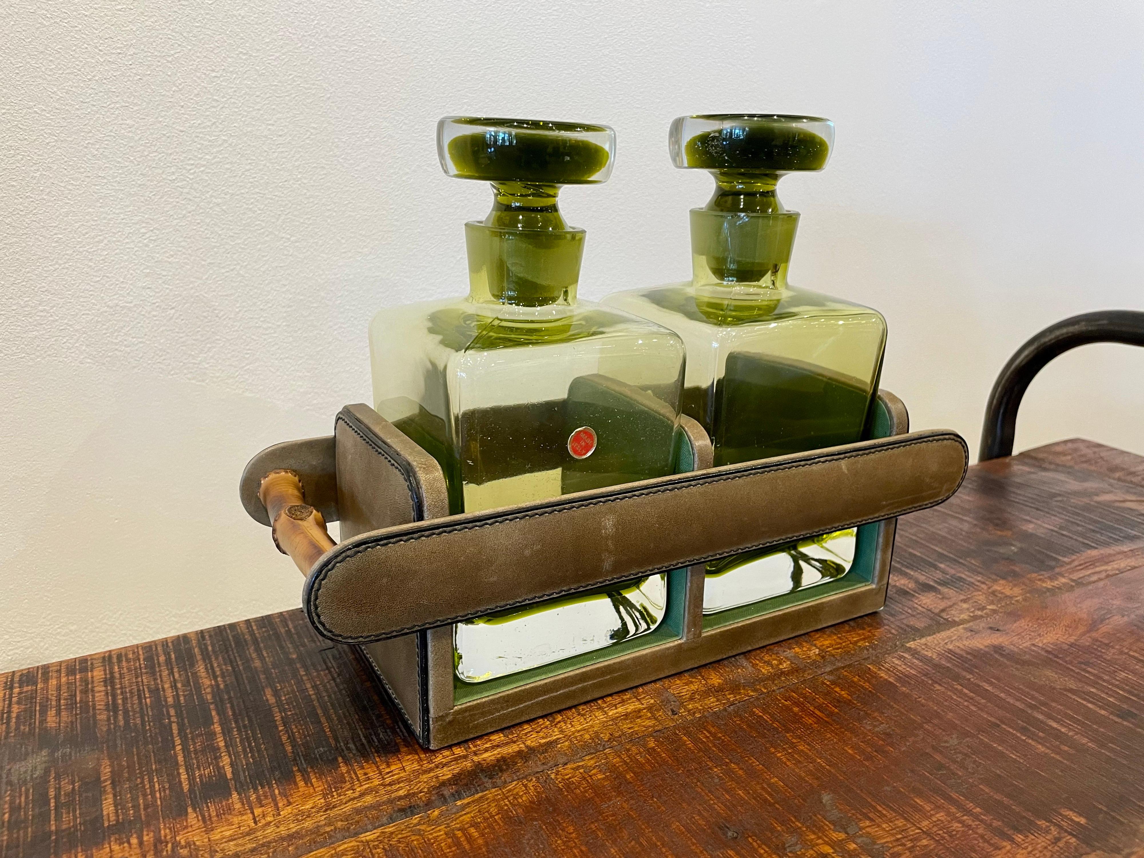 An amazing Vintage Set of Green glass decanters with a beautiful stitched green leather holder and bamboo handles. The whole thing just screams of luxury and beauty.