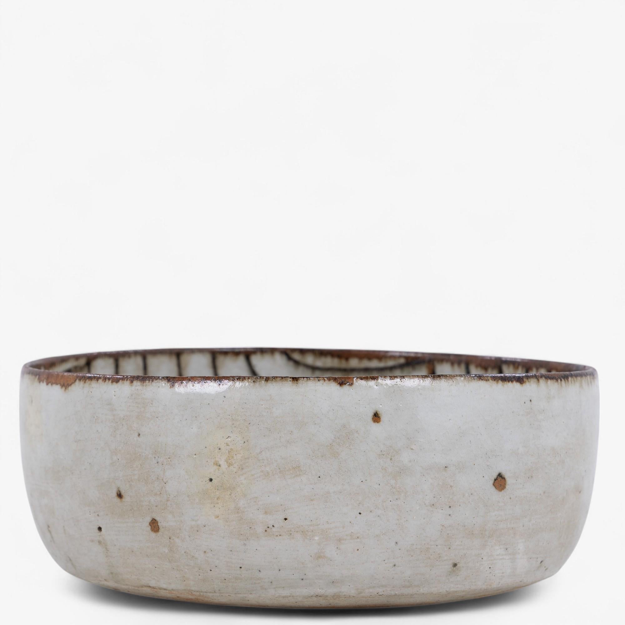 Rare and large circular bowl in glazed stoneware decorated with a curved line pattern and transparent grey-blue glaze. Stamped by Gertrud Vasegaard.