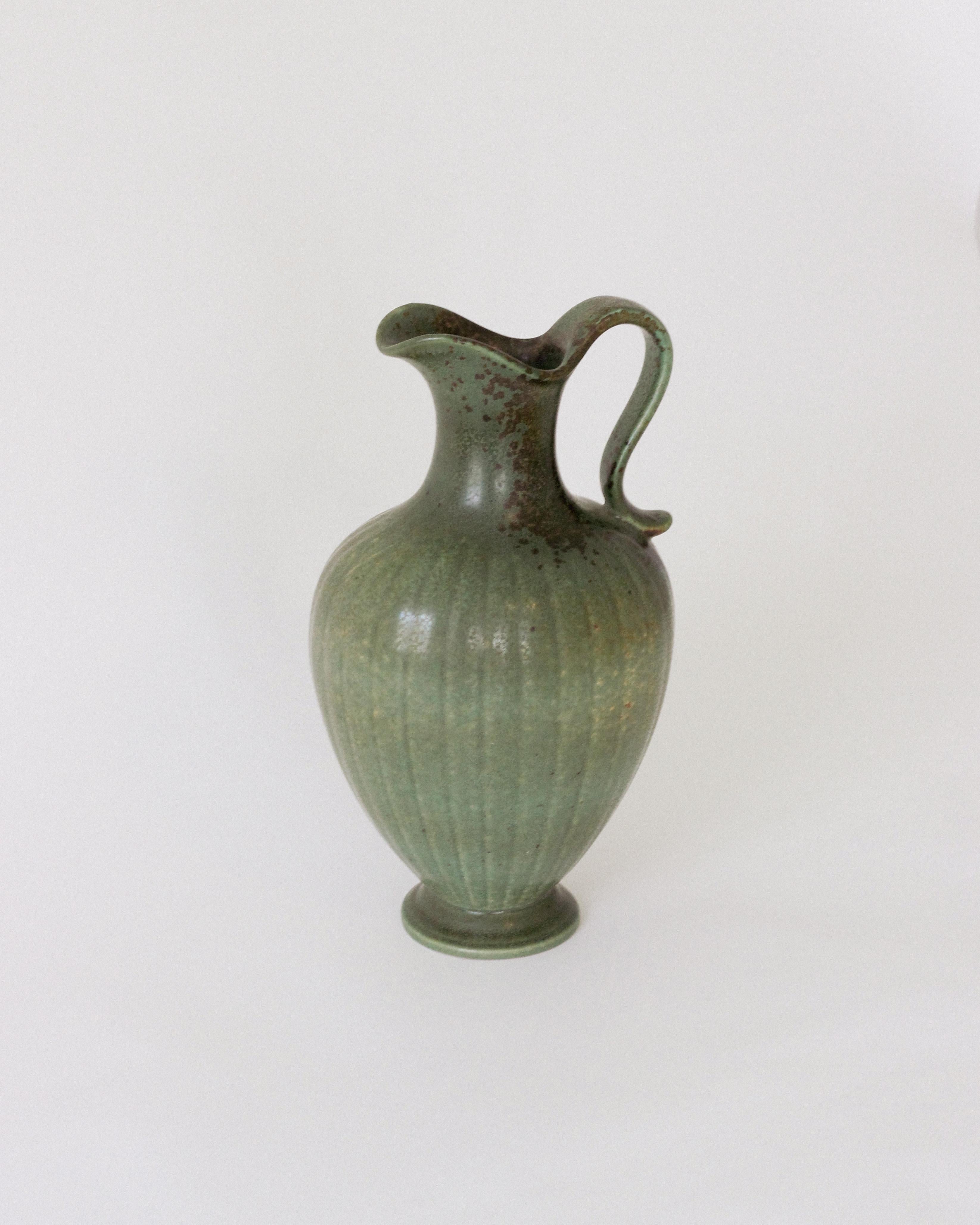 Impeccable and rare stoneware pitcher produced by Rörstrands, Sweden, 1940s. Designed and signed by Gunnar Nylund, (Swedish, 1914-1997).

Nylund served as artistic director at Rörstrands, where he worked 1931-1955. Prior to his work at Rörstrand he