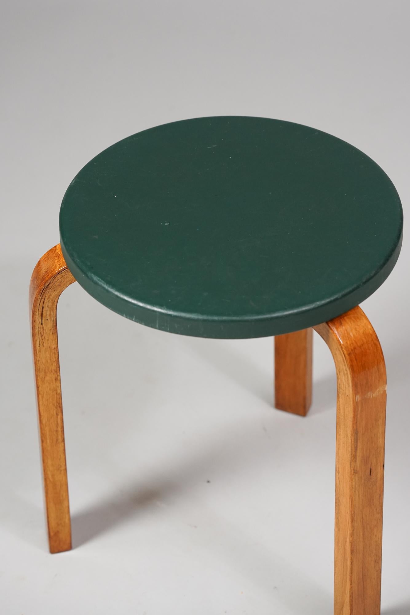 Taburete modelo 60 de Alvar Aalto para Artek de la década de 1950. Abedul con imitación de cuero de color raro. Buen estado vintage, pátina y desgaste acordes con la edad y el uso. Bonita pátina de color miel en las piezas de abedul. Diseño icónico