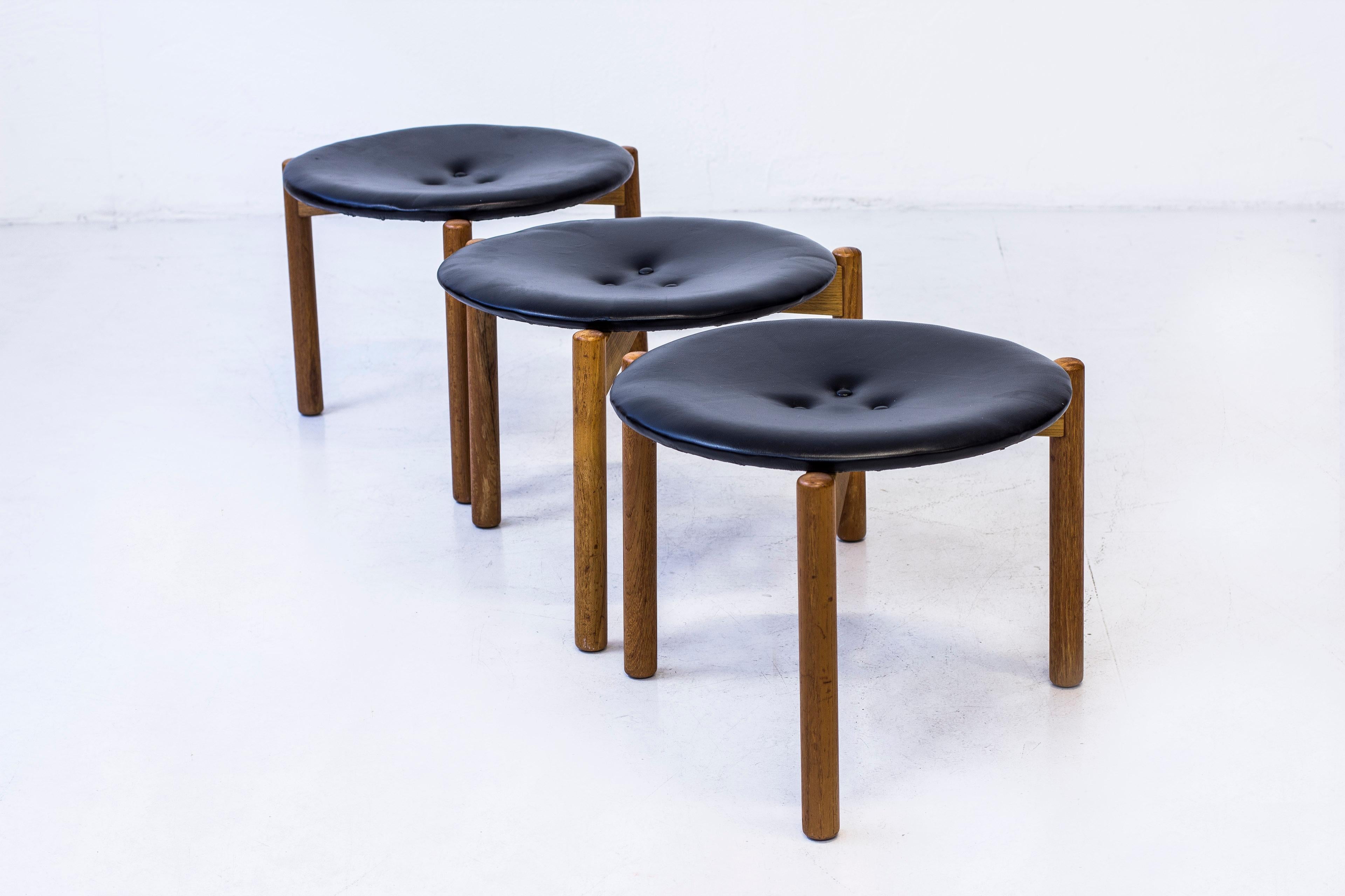 Very rare stools deigned by Uno & Östen Kristiansson. Produced by Luxus in Vittsjö, Sweden during the 1960s. Made from solid oak and teak wood in the base with black leather seats. Very good condition with very few signs of age and wear. Three
