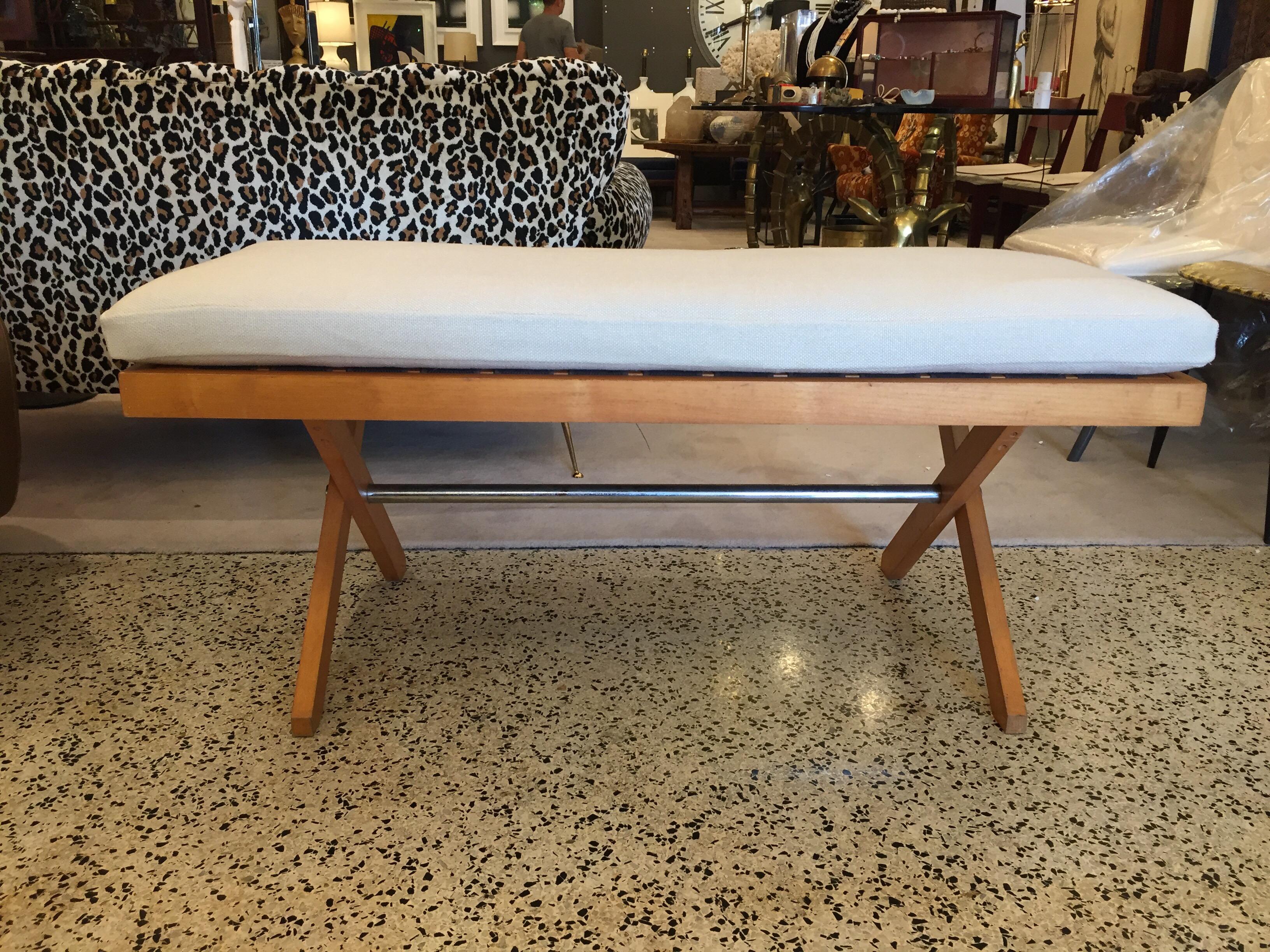 Rare vintage modern bench circa 1950s in the style of Pierre Jeanneret, loose pillow upholstered in an off-white padded natural fabric resting on x like legs and metal crossbar, with the original nylon webbing.