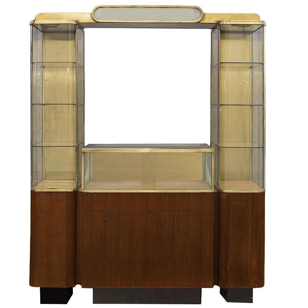 Rara vetrina a doppia torre in stile Art Déco, composta da una vetrina centrale a livello della vita con un piano d'appoggio e una serie di torri, una per lato. Ogni vetrina è realizzata in ottone massiccio con lati in vetro arrotondati e curvi ed è