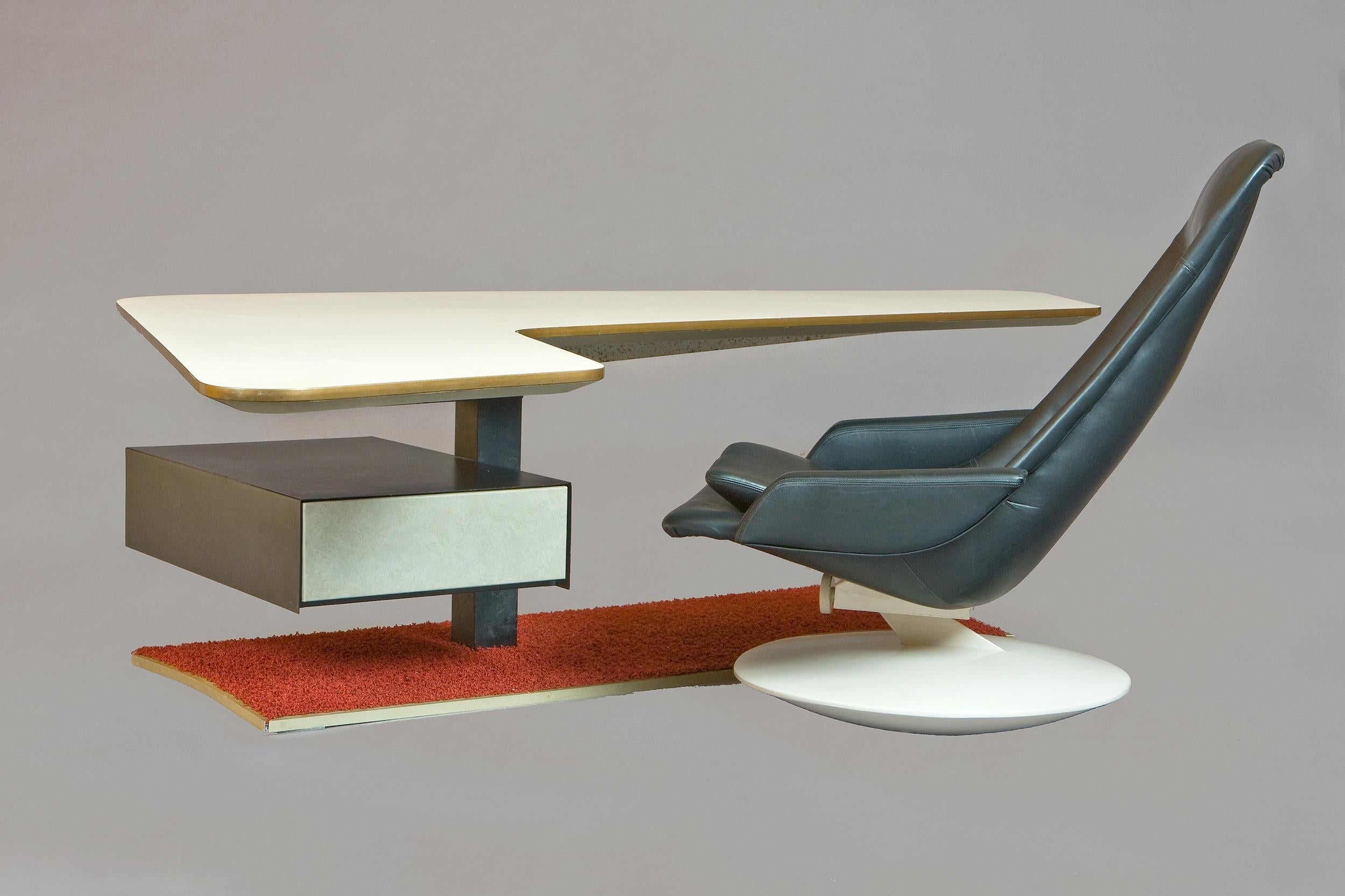 Frankreich, 1970er Jahre

Ein phänomenaler Bumerang-Schreibtisch aus der Raumfahrt. Eine wunderschön langgestreckte und abgewinkelte Formica-Platte ragt über eine Stahlsäule mit einer gefederten Schublade mit Fächern, die auf einem gusseisernen