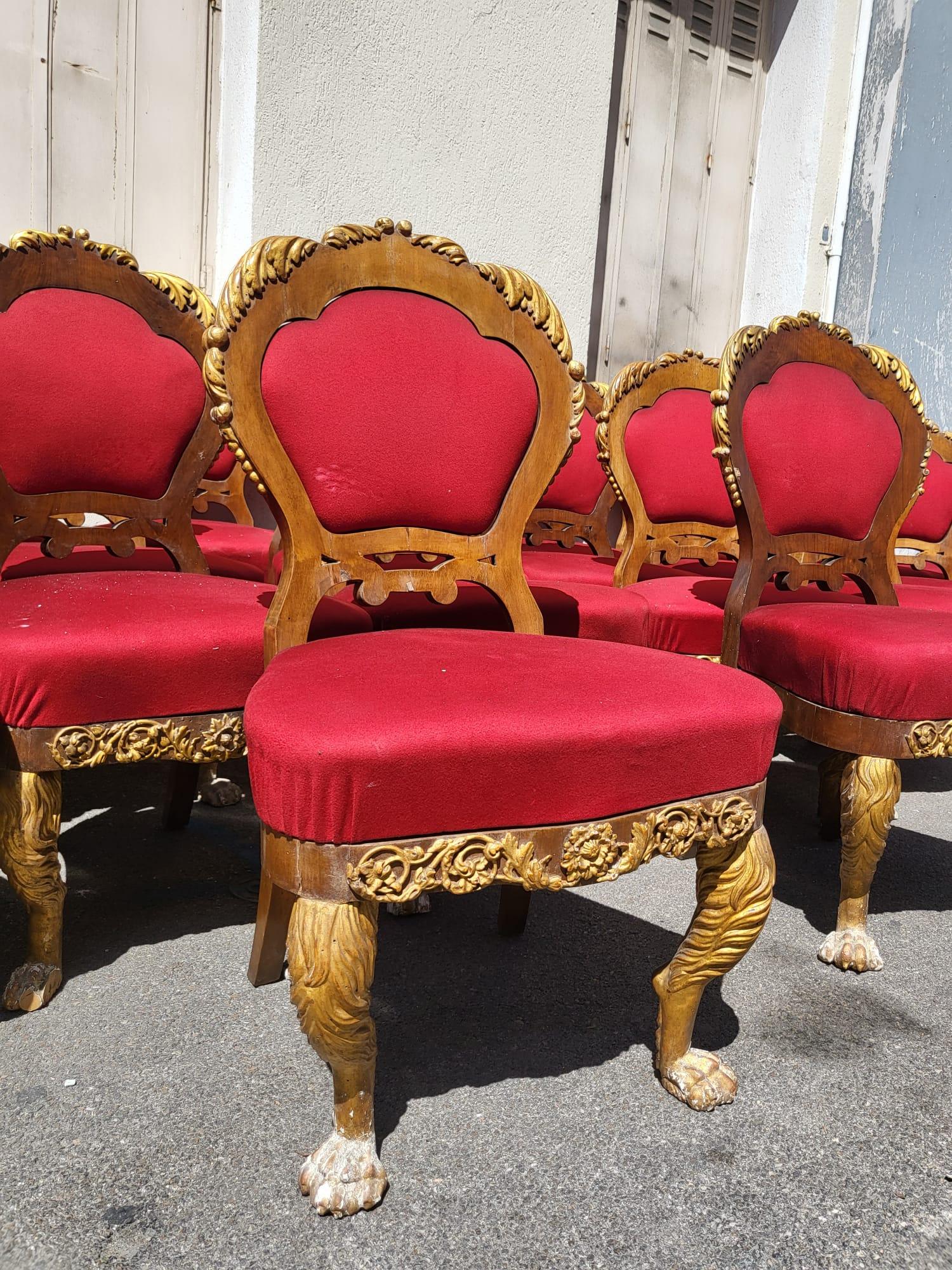 Raro set di 20 sedie in legno e legno dorato, modelli con struttura (sedili e schienali), con piedi anteriori a forma di zampa di leone.

I sedili e gli schienali sono rivestiti in tessuto rosso.

20 sedie così come sono, la maggior parte da